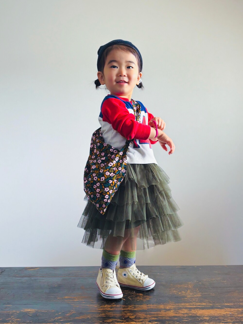 ホワイト系のスニーカー、グリーン系のスカート、その他のショルダーバッグを着用したキッズの春コーディネートの3枚目の写真