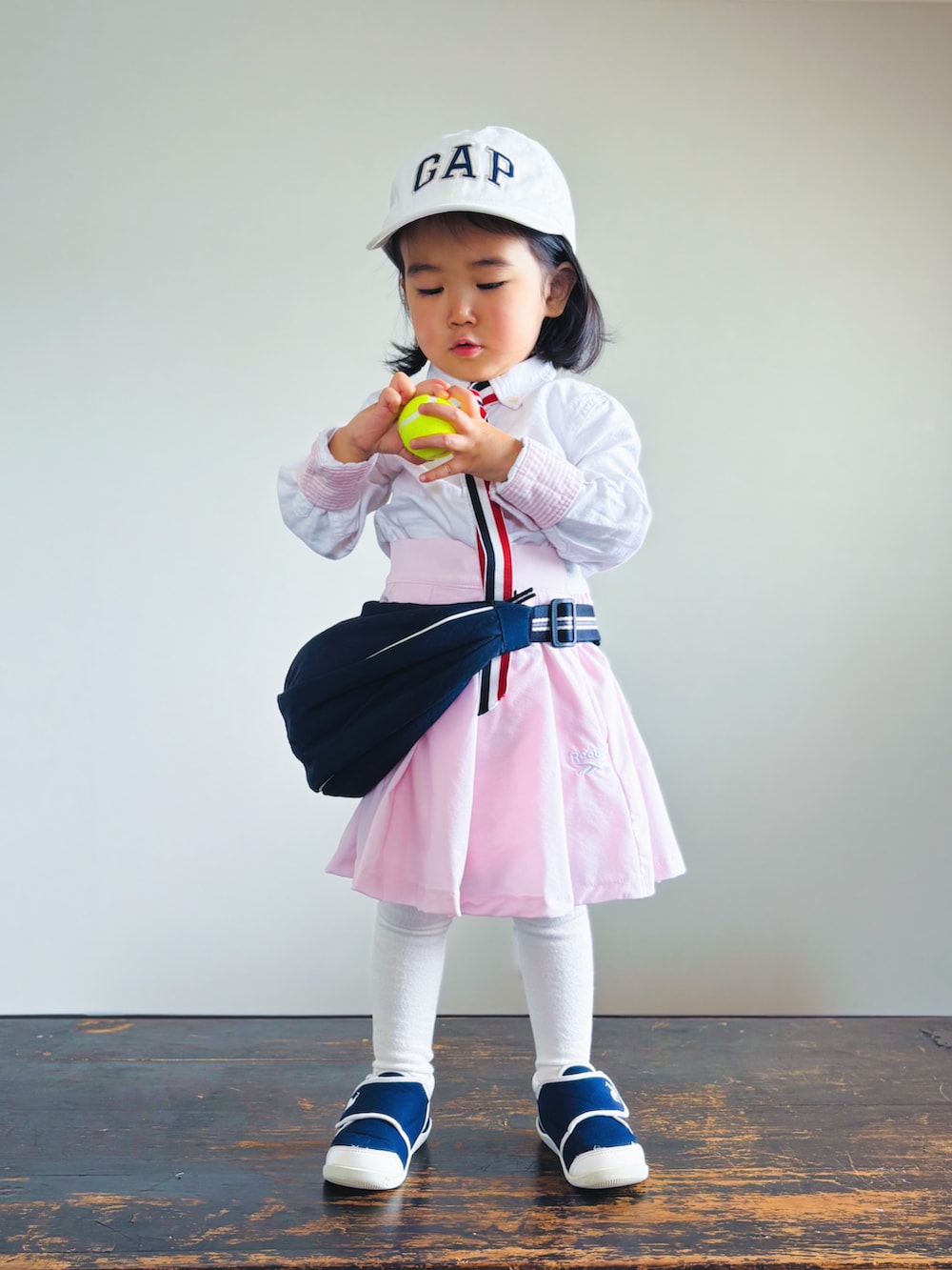 ブルー系のスニーカー、ピンク系のスカート、ブルー系のショルダーバッグを着用したキッズの春コーディネートの3枚目の写真