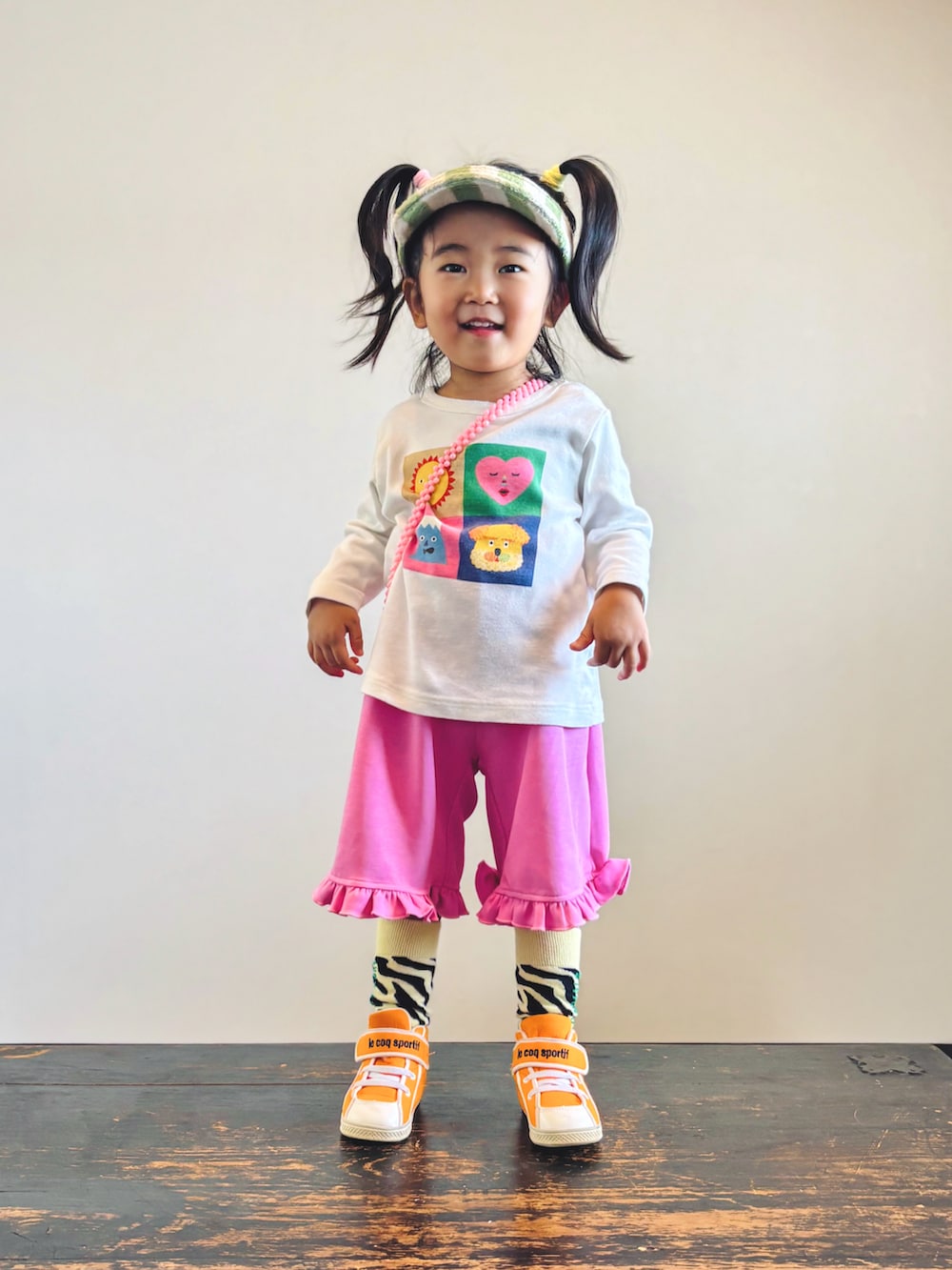 ピンク系のその他パンツ、オレンジ系のスニーカー、ホワイト系のTシャツ/カットソーを着用したキッズの秋コーディネートの3枚目の写真