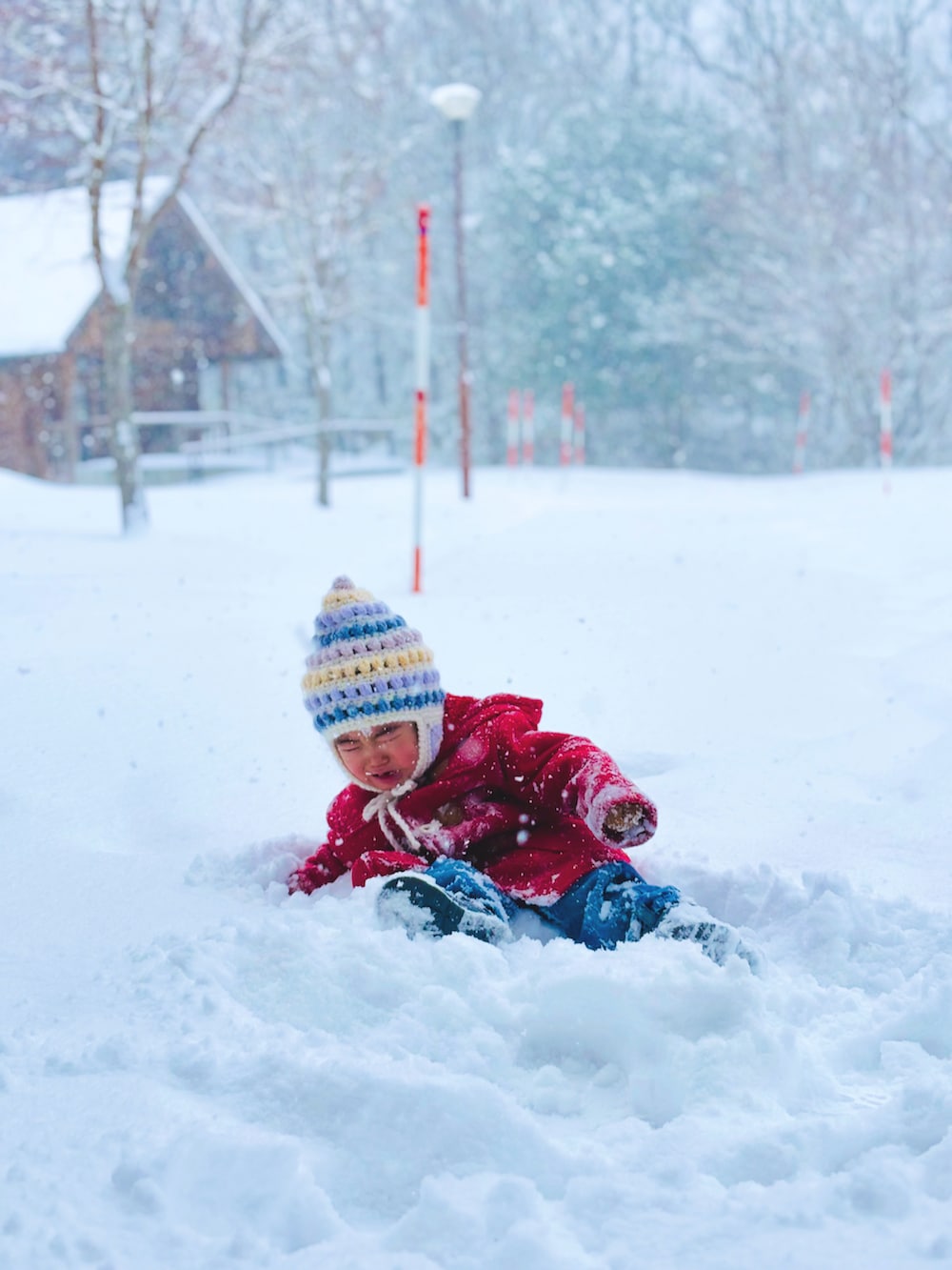 レッド系のダッフルコート、ブルー系のデニムパンツ、グレー系のブーツを着用したキッズの冬コーディネートの2枚目の写真