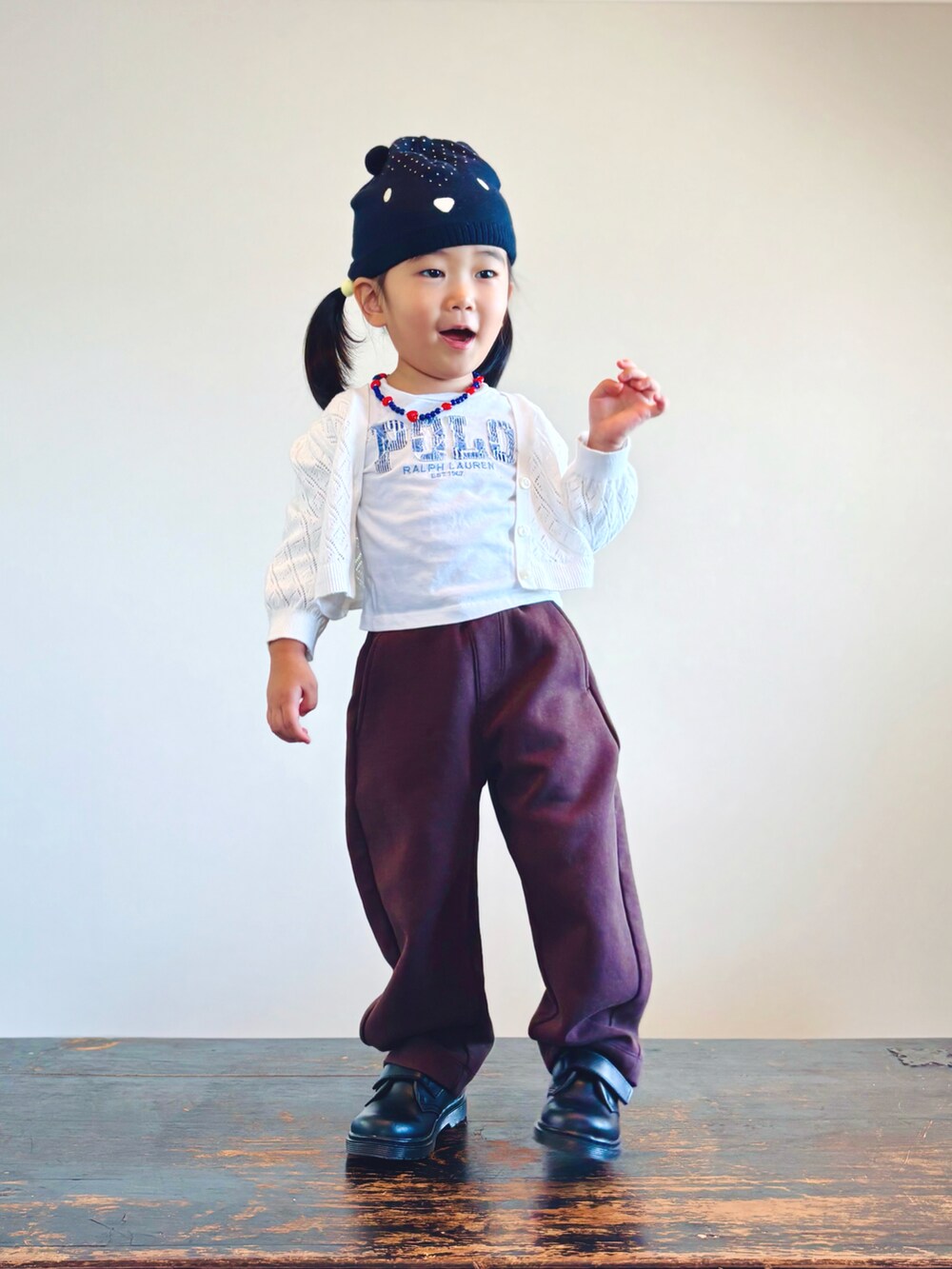 ホワイト系のカーディガン/ボレロ、ホワイト系のTシャツ/カットソー、ブラウン系のスウェットパンツを着用したキッズの秋コーディネートの3枚目の写真