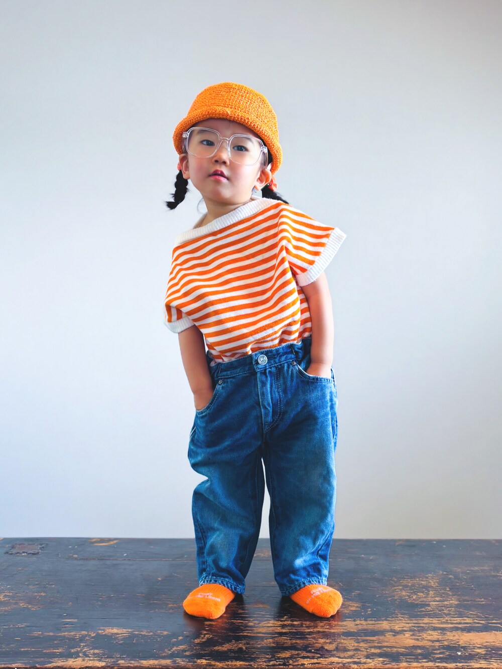 ブルー系のデニムパンツ、オレンジ系のTシャツ/カットソー、その他のソックス/靴下を着用したキッズの夏コーディネートの3枚目の写真