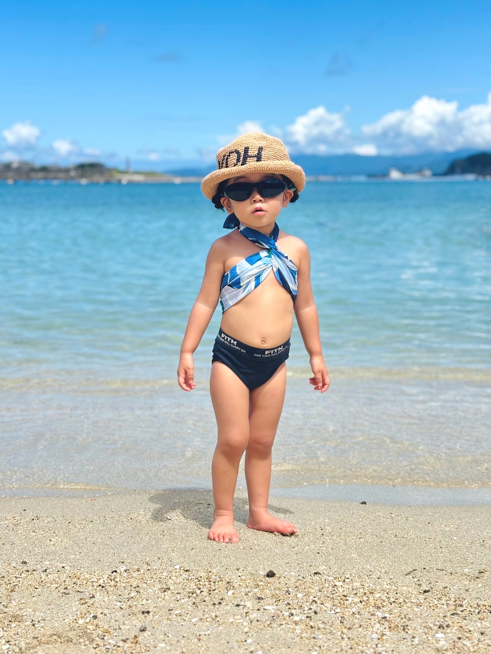 ブラック系のサングラス、ブルー系のバンダナ/スカーフ、ベージュ系のハットを着用したキッズの夏コーディネートの3枚目の写真