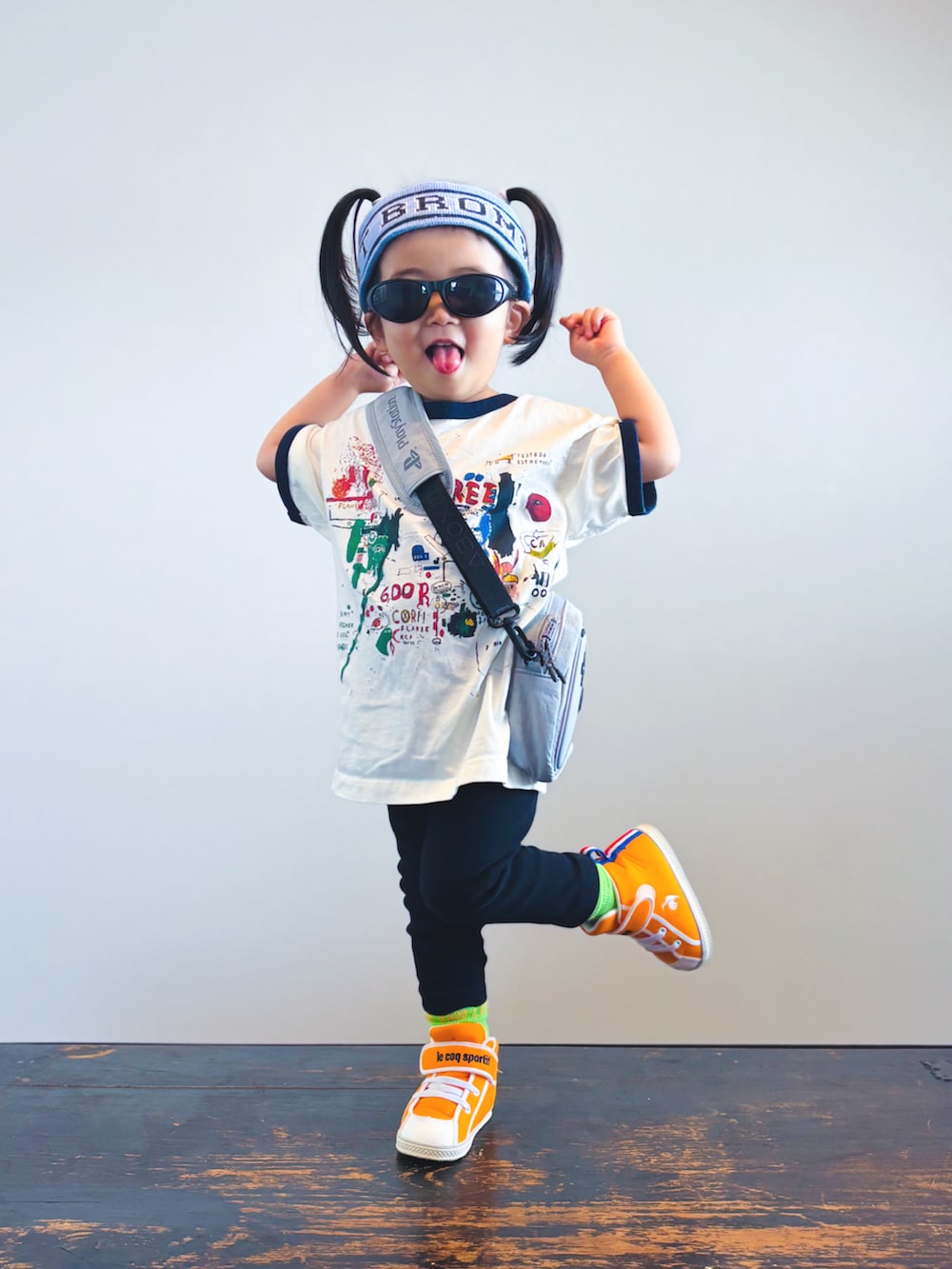 オレンジ系のスニーカー、ホワイト系のTシャツ/カットソー、ブラック系のパンツを着用したキッズの夏コーディネートの2枚目の写真