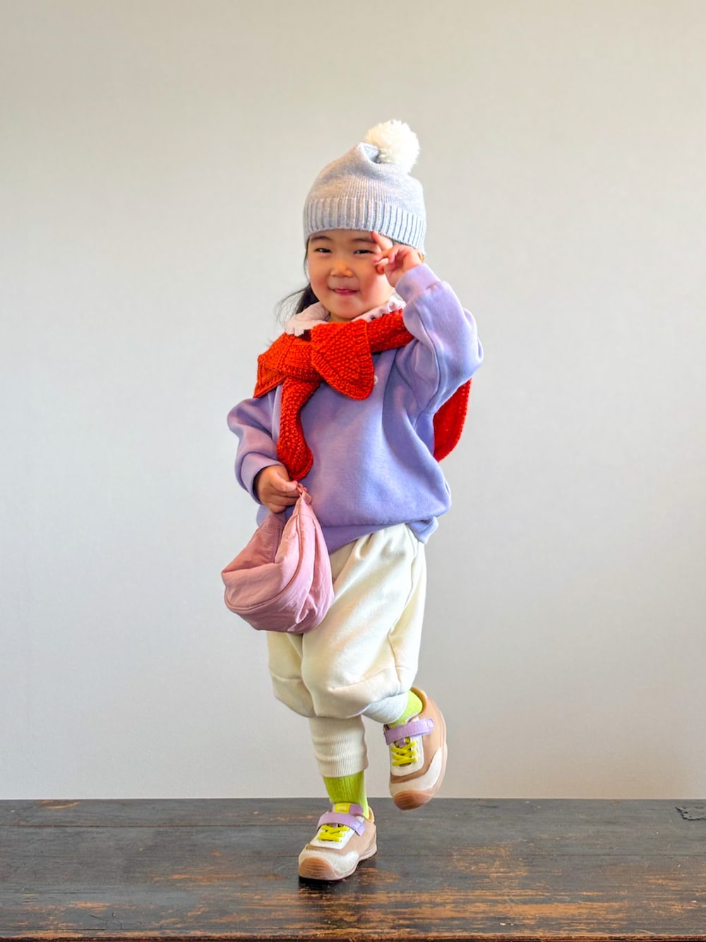 パープル系のスウェット、イエロー系のスニーカー、ピンク系のTシャツ/カットソーを着用したキッズの秋コーディネートの3枚目の写真