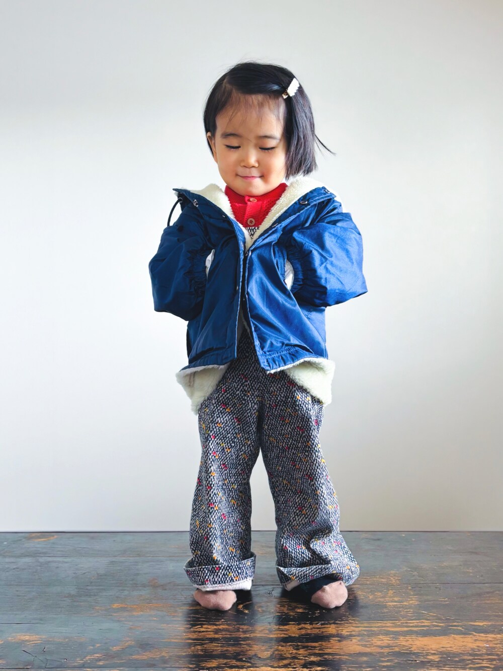 ブルー系のナイロンジャケット、レッド系のカーディガン/ボレロ、ホワイト系のシャツ/ブラウスを着用したキッズの冬コーディネートの2枚目の写真