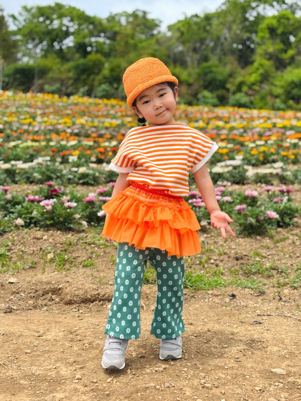 グリーン系のその他パンツ、オレンジ系のスカート、グレー系のスニーカーを着用したキッズの春コーディネートの3枚目の写真
