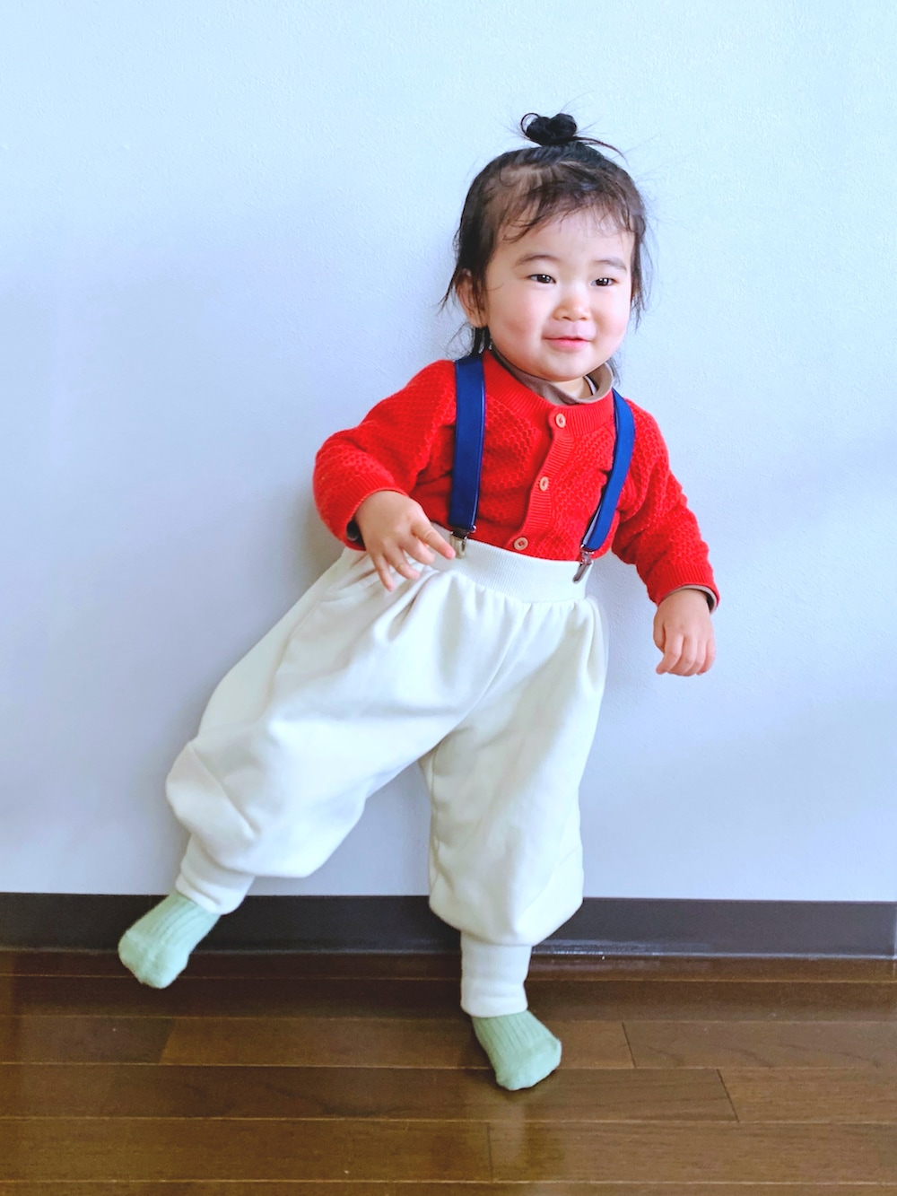 ベージュ系のパンツ、レッド系のカーディガン/ボレロ、ブラウン系のTシャツ/カットソーを着用したキッズの春コーディネートの2枚目の写真