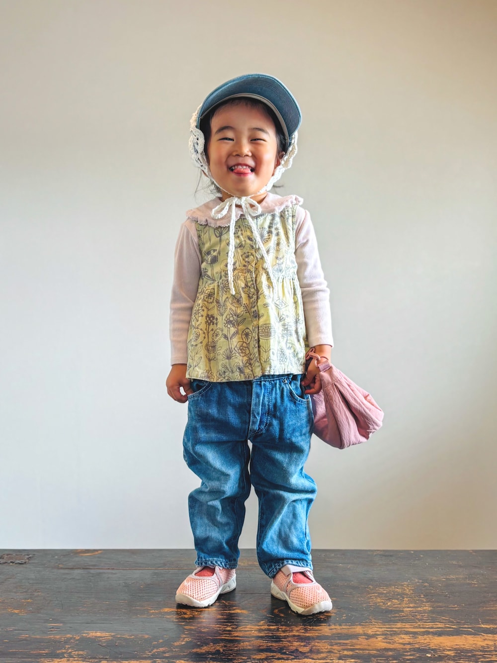 ピンク系のスニーカー、ピンク系のTシャツ/カットソー、ブルー系のデニムパンツを着用したキッズの秋コーディネートの4枚目の写真