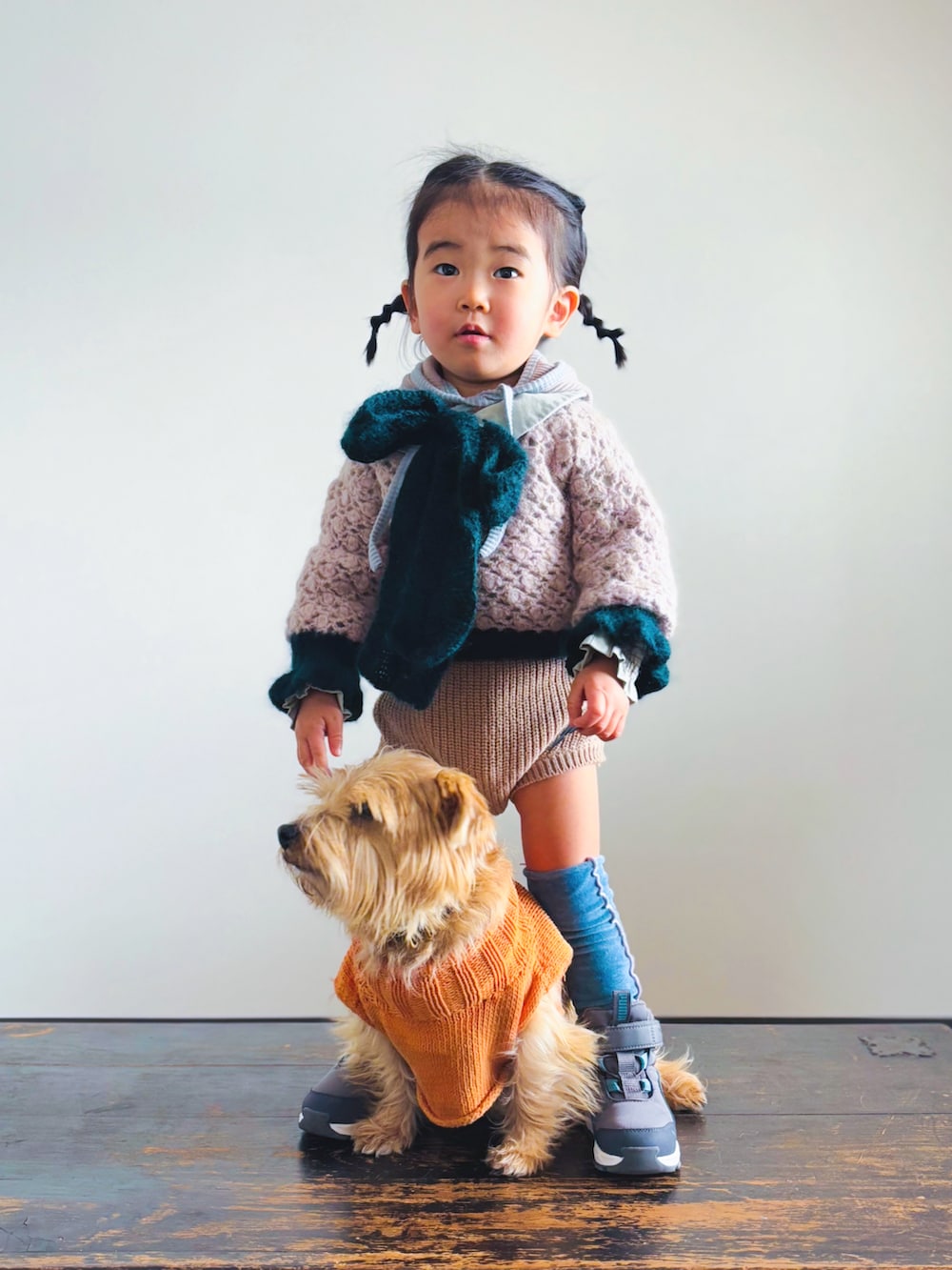 ピンク系のニット/セーター、グリーン系のシャツ/ブラウス、ブラウン系のセットアップを着用したキッズの冬コーディネートの3枚目の写真