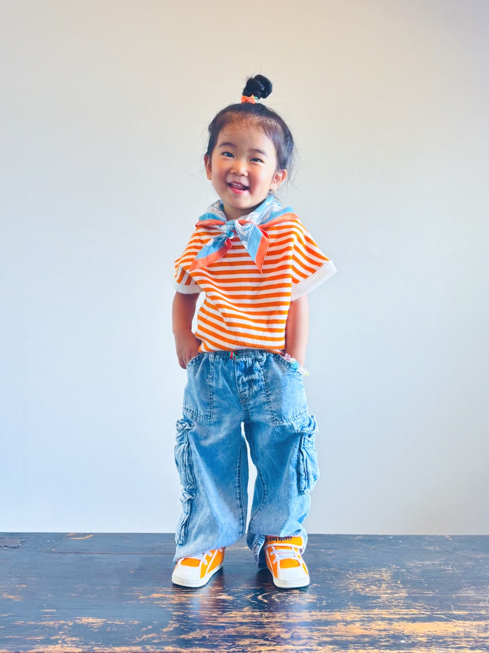 ブルー系のデニムパンツ、オレンジ系のスニーカー、オレンジ系のTシャツ/カットソーを着用したキッズの秋コーディネートの2枚目の写真