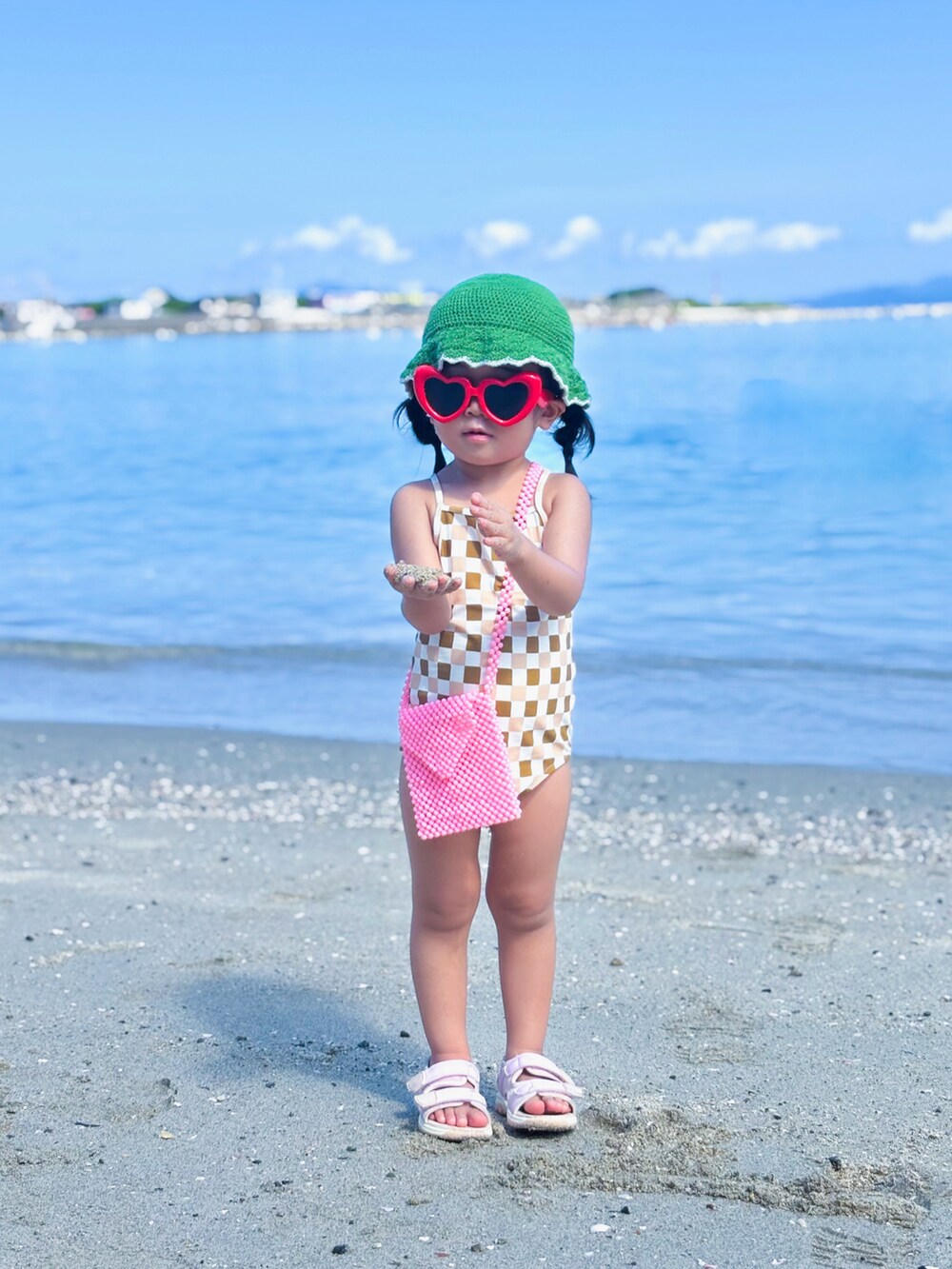 ピンク系のショルダーバッグ、ピンク系のサンダル、その他のその他ベビー用品を着用したキッズの夏コーディネートの2枚目の写真