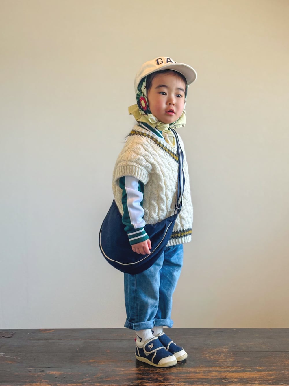 ブルー系のスニーカー、ホワイト系のベスト、グリーン系のジャージを着用したキッズの春コーディネートの3枚目の写真