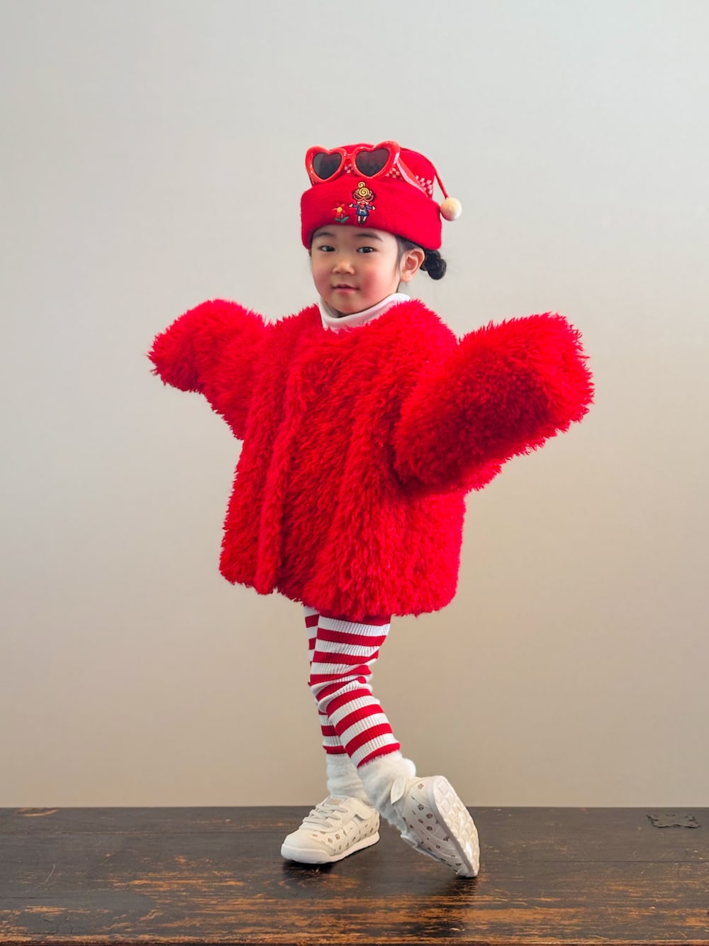 ホワイト系のTシャツ/カットソー、ベージュ系のスニーカー、レッド系のブルゾンを着用したキッズの冬コーディネートの3枚目の写真