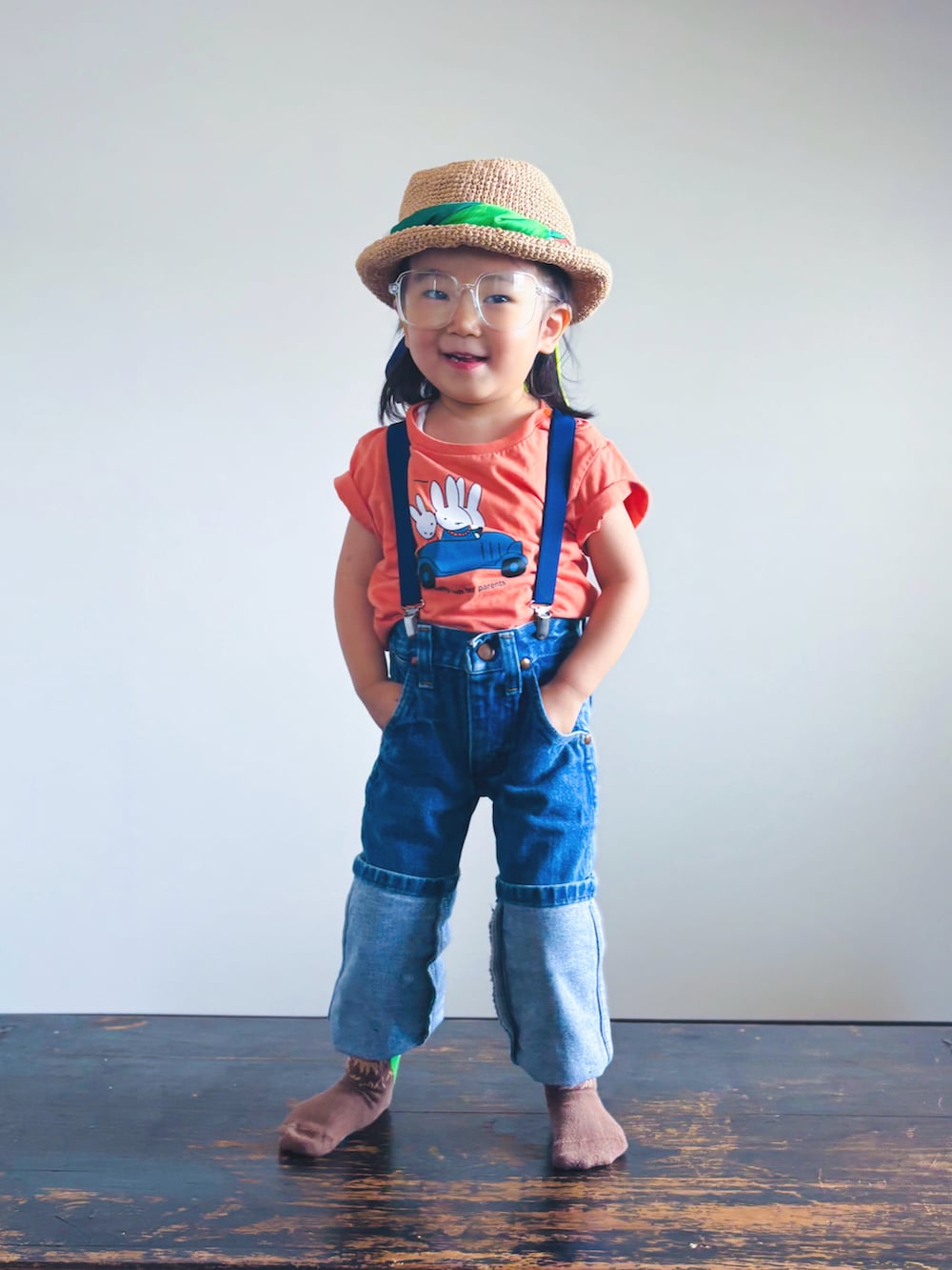 オレンジ系のTシャツ/カットソー、ブルー系のデニムパンツ、ホワイト系のメガネを着用したキッズの夏コーディネートの5枚目の写真