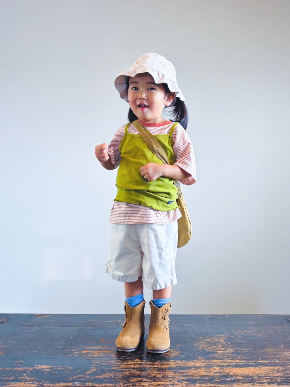 オレンジ系のTシャツ/カットソー、グリーン系のキャミソール、ホワイト系のその他パンツを着用したキッズの秋コーディネートの2枚目の写真