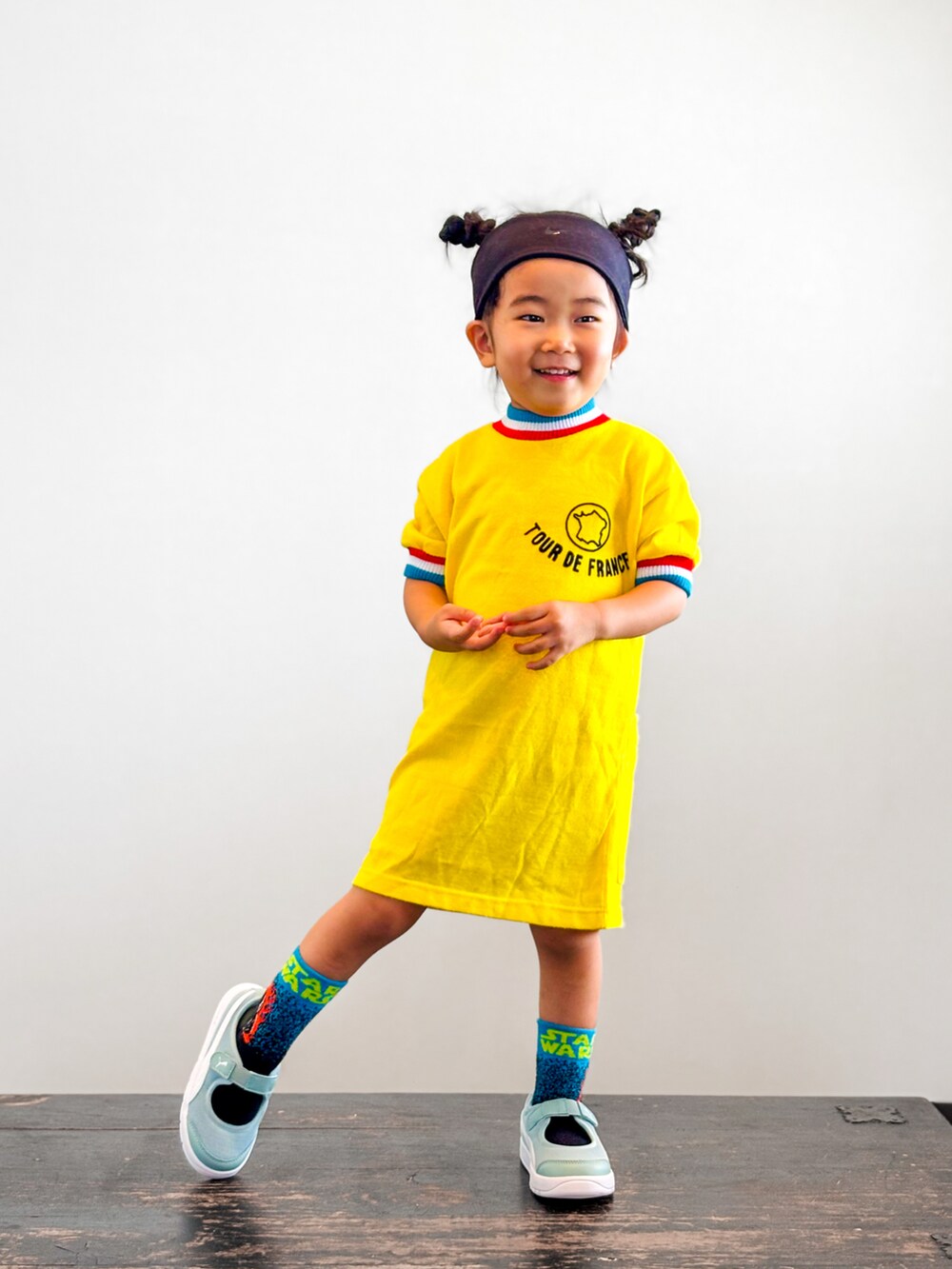 グリーン系のスニーカー、イエロー系のTシャツ/カットソー、ブラック系のヘアバンドを着用したキッズの夏コーディネートの2枚目の写真