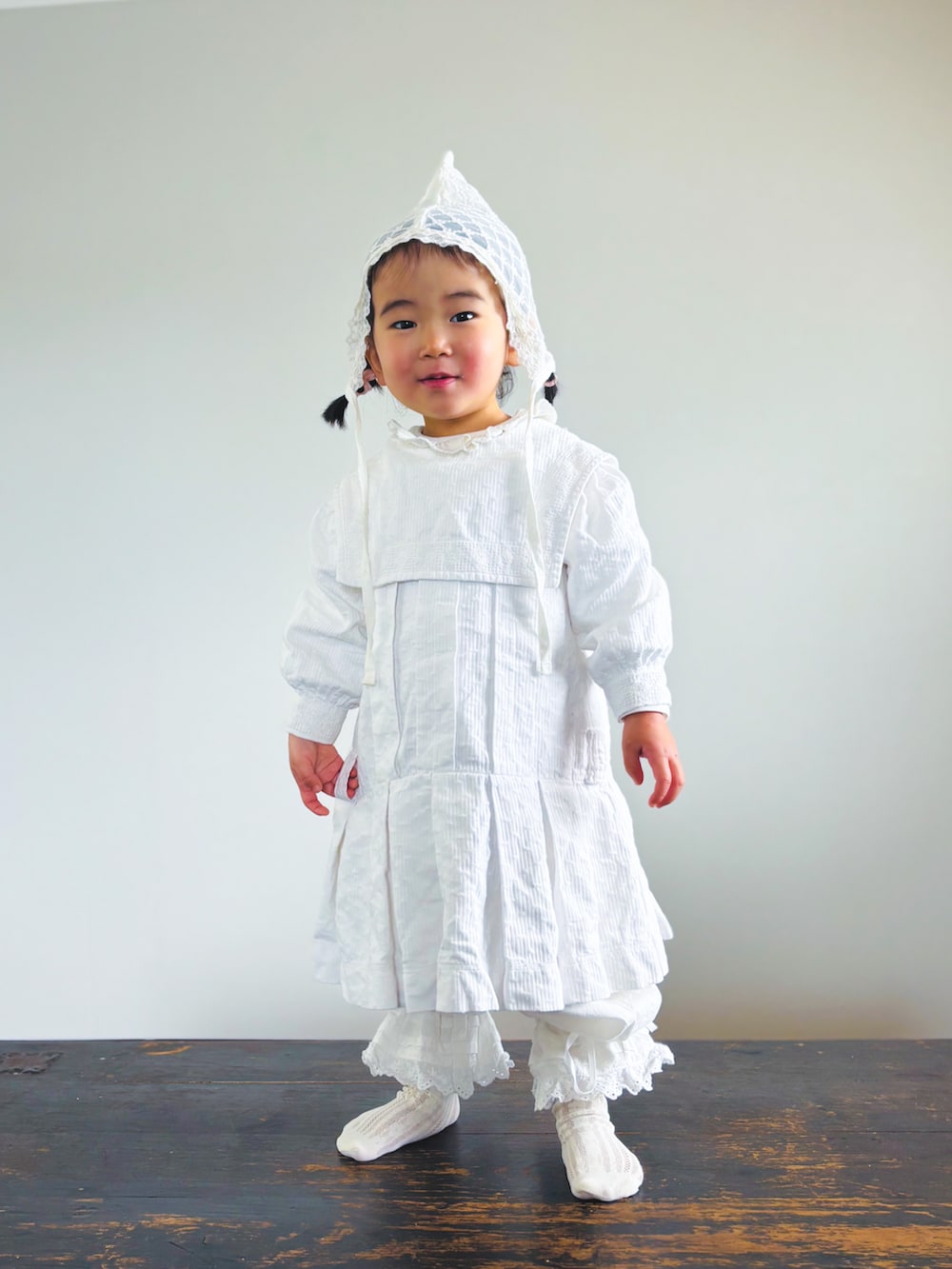 ホワイト系のワンピース、ホワイト系のTシャツ/カットソー、ホワイト系のその他パンツを着用したキッズの春コーディネートの3枚目の写真