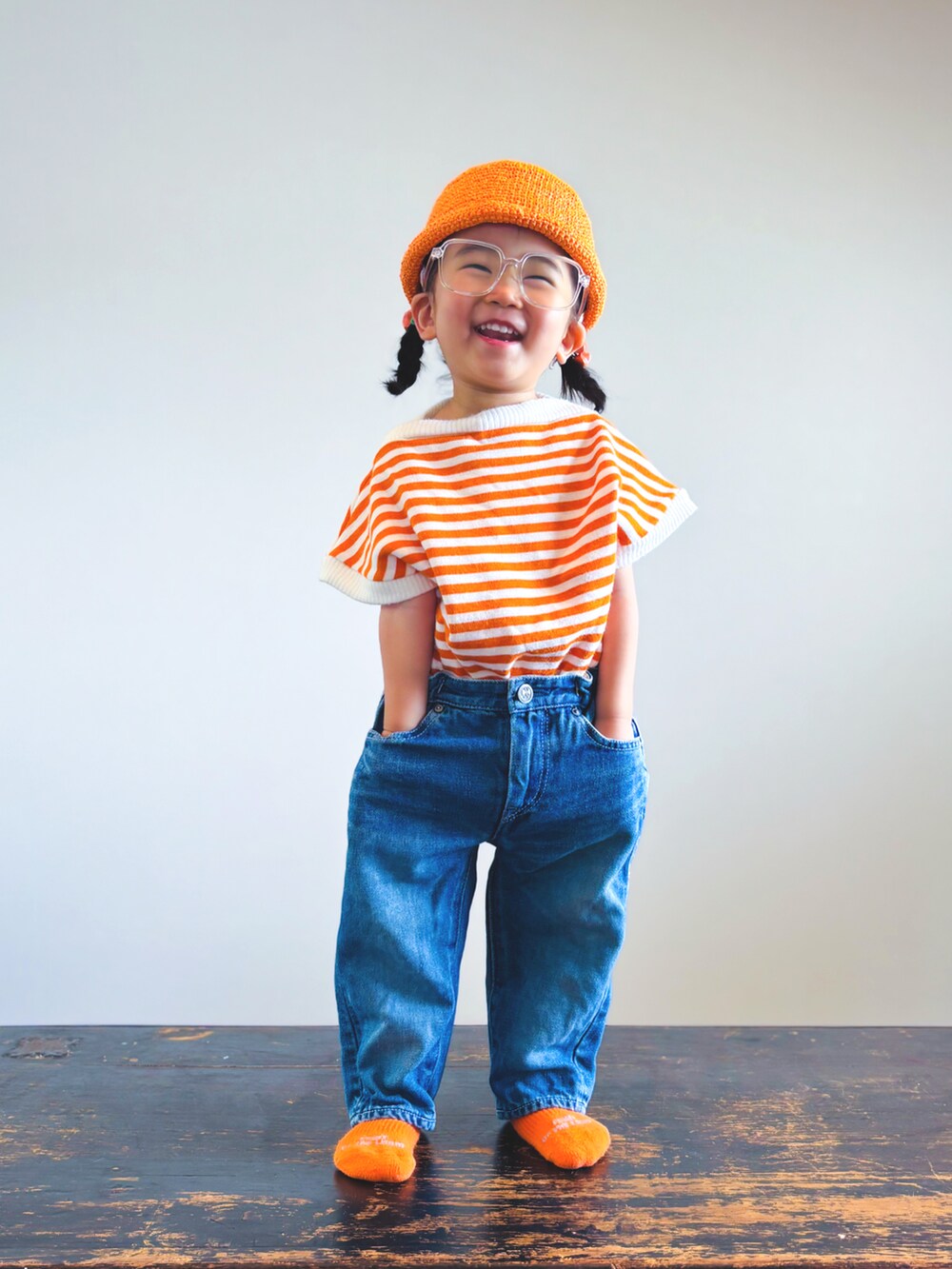 ブルー系のデニムパンツ、オレンジ系のTシャツ/カットソー、その他のソックス/靴下を着用したキッズの夏コーディネートの2枚目の写真