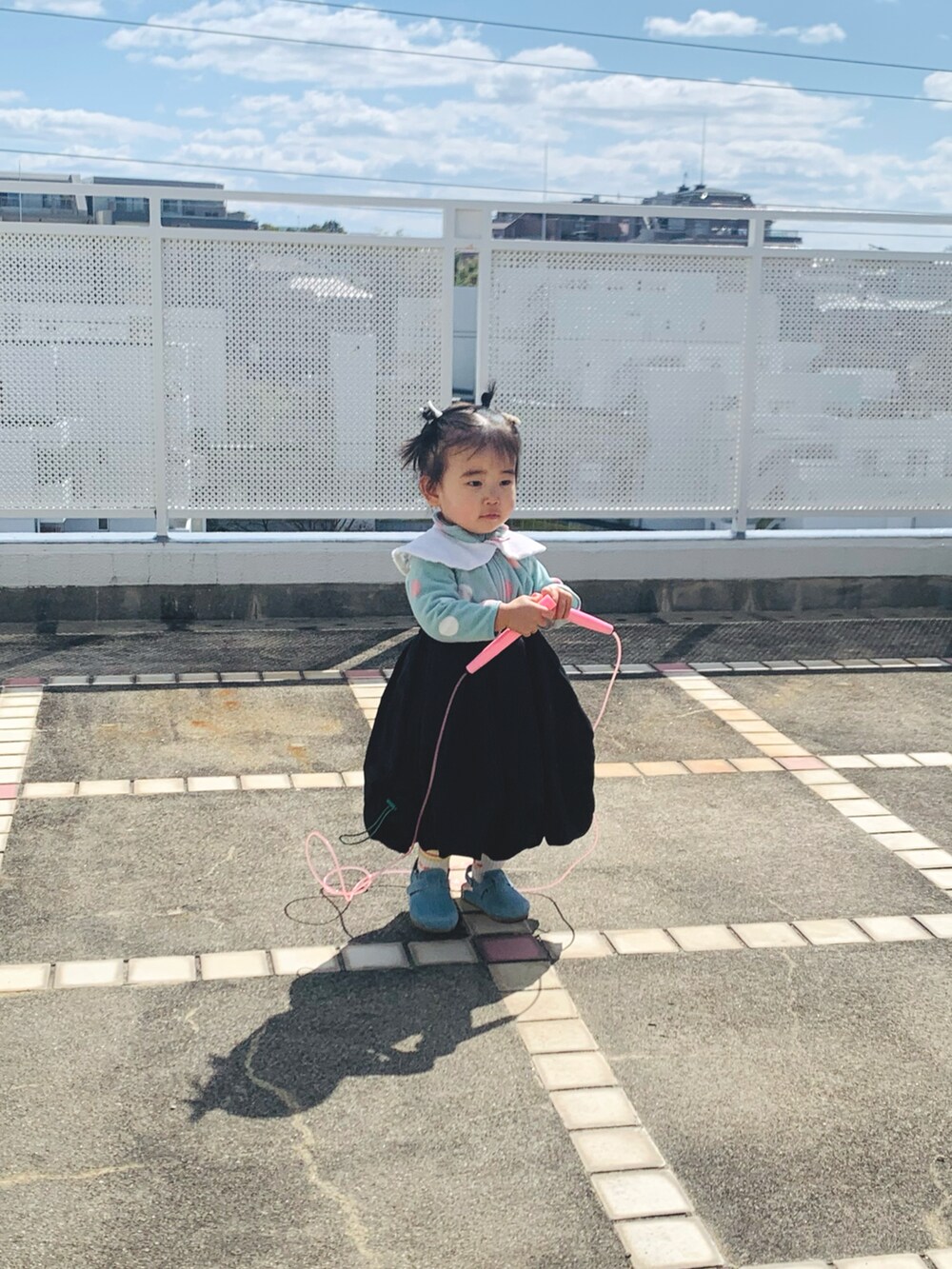 ブラック系のスカート、ブルー系のジャケット/アウター、イエロー系のソックス/靴下を着用したキッズの春コーディネートの2枚目の写真