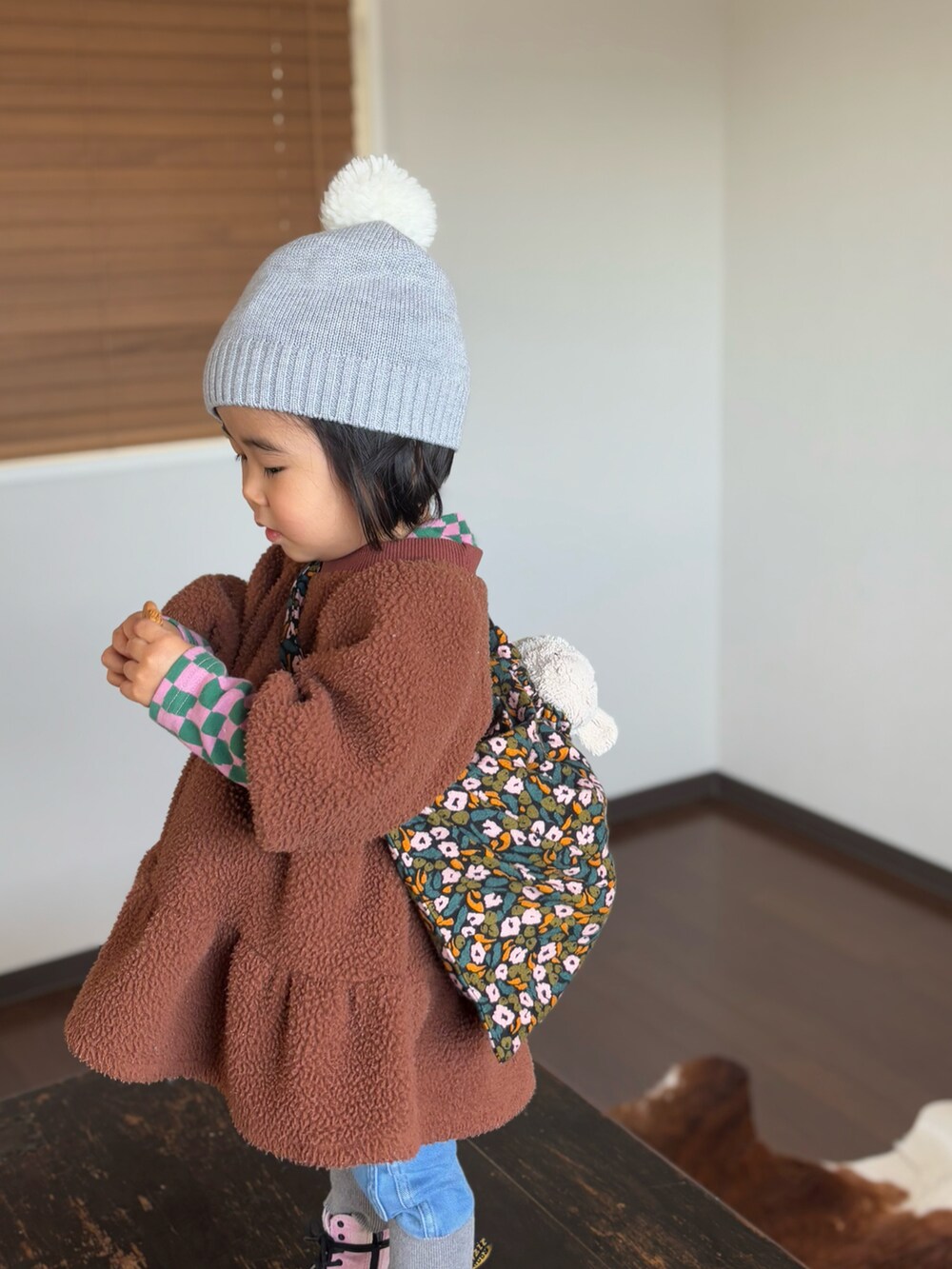 ピンク系のブーツ、ブルー系のデニムパンツ、ブラウン系のワンピースを着用したキッズの冬コーディネートの3枚目の写真