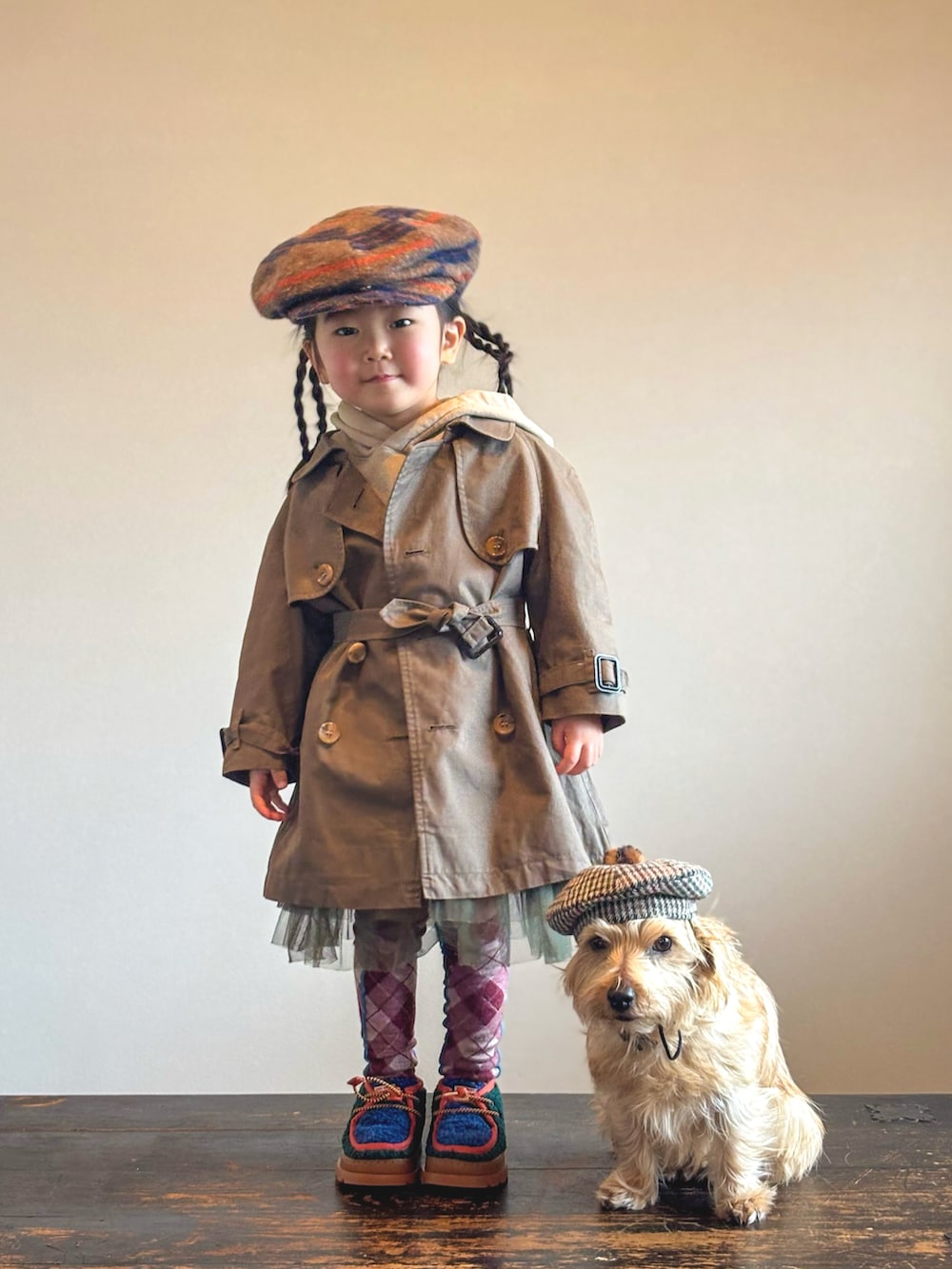 グリーン系のブーツ、グリーン系のスカート、ベージュ系のパーカーを着用したキッズの春コーディネートの3枚目の写真