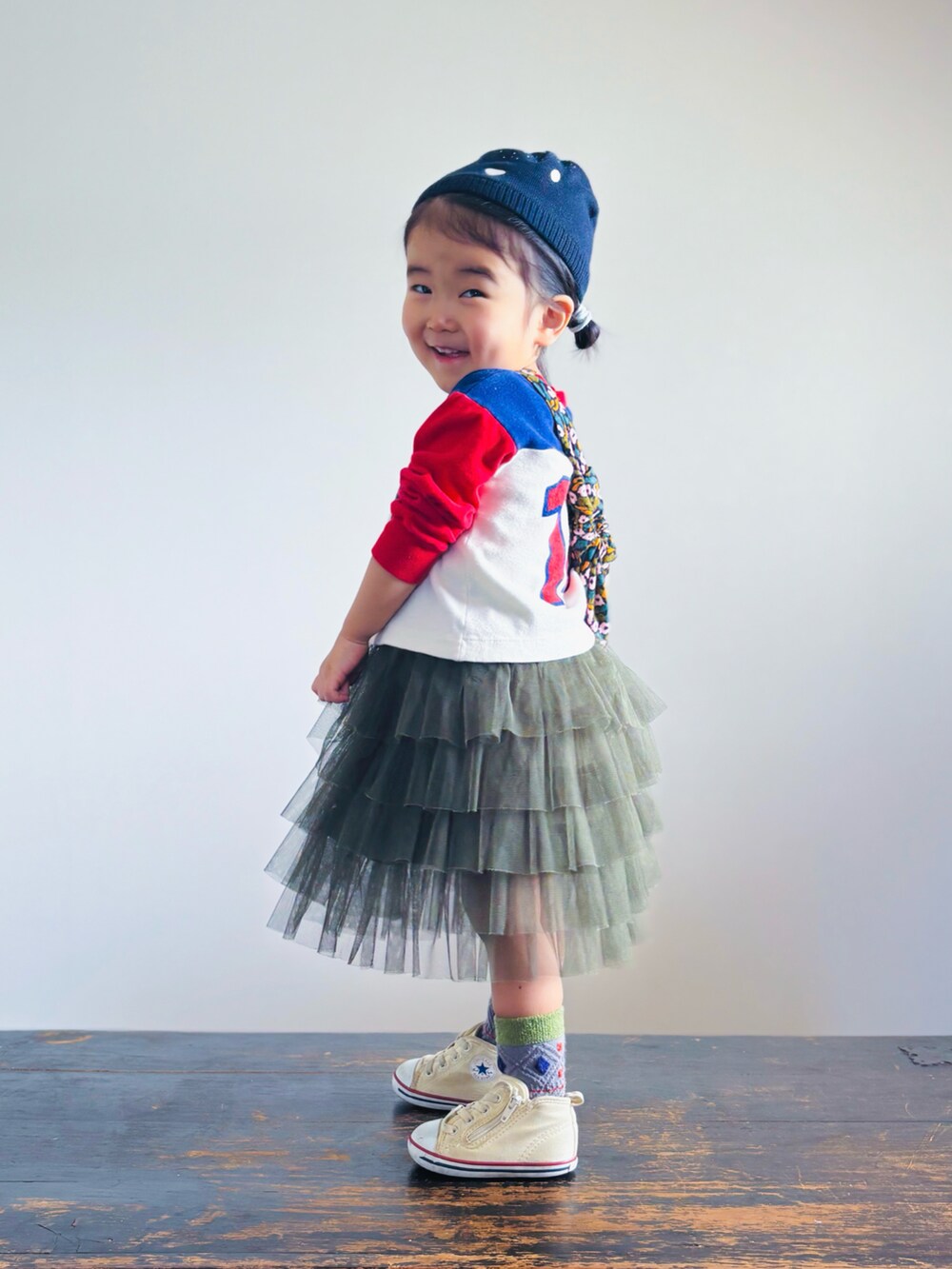 ホワイト系のスニーカー、グリーン系のスカート、その他のショルダーバッグを着用したキッズの春コーディネートの2枚目の写真