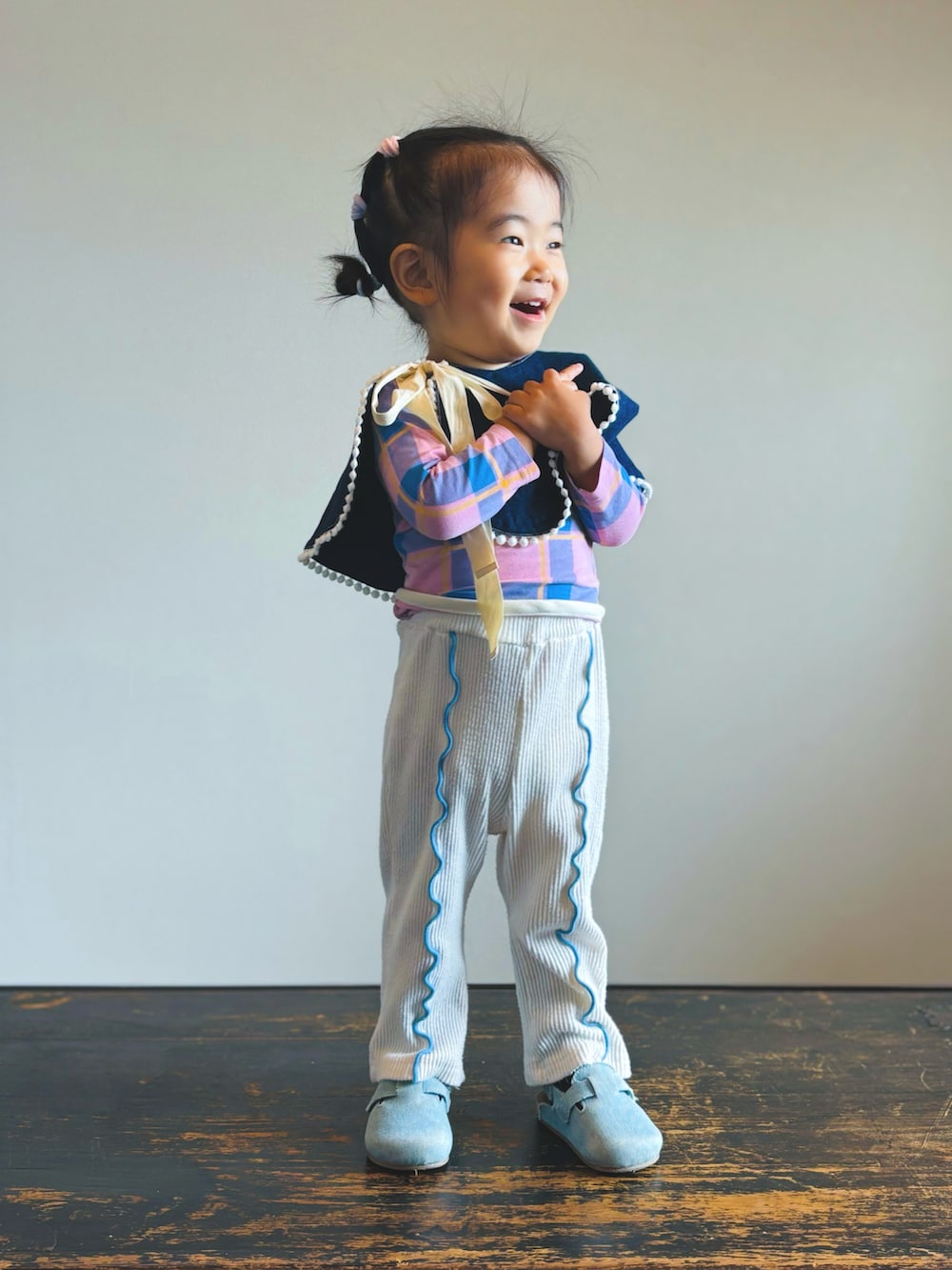 ブルー系のサンダル、ホワイト系のレギンス/スパッツ、ピンク系のロンパースを着用したキッズの秋コーディネートの2枚目の写真