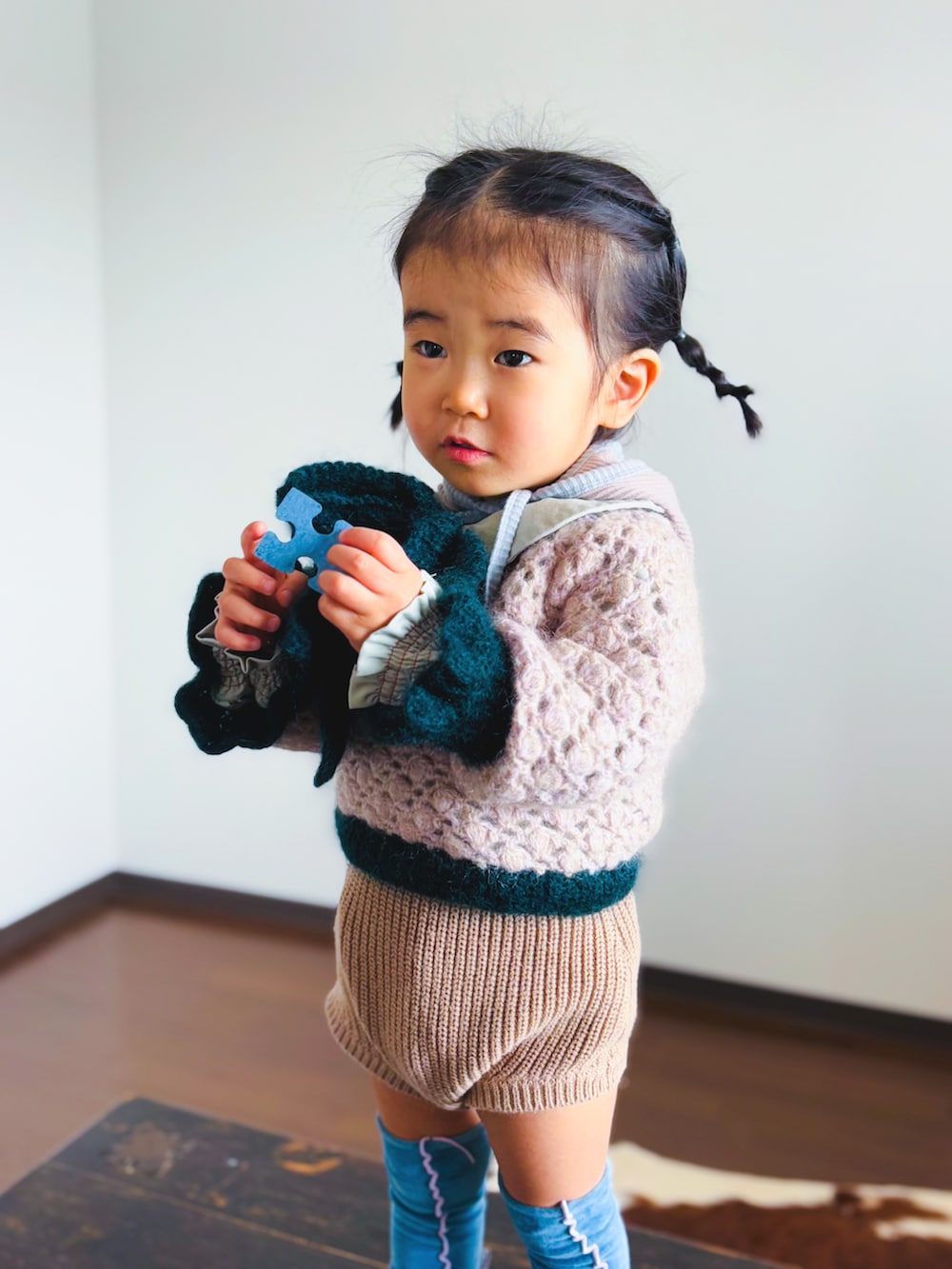 ピンク系のニット/セーター、グリーン系のシャツ/ブラウス、ブラウン系のセットアップを着用したキッズの冬コーディネートの4枚目の写真