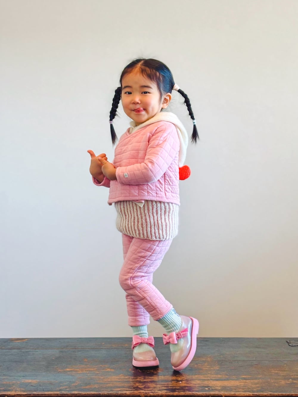 ホワイト系のベスト、ピンク系のバレエシューズ、その他のソックス/靴下を着用したキッズの冬コーディネートの2枚目の写真