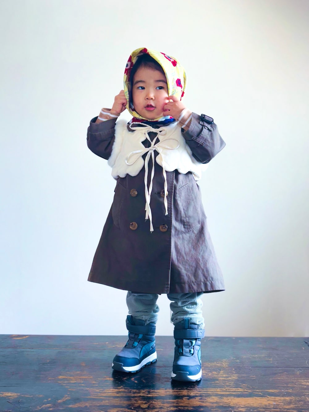 グリーン系のトレンチコート、グリーン系のその他パンツ、グレー系のブーツを着用したキッズの冬コーディネートの2枚目の写真