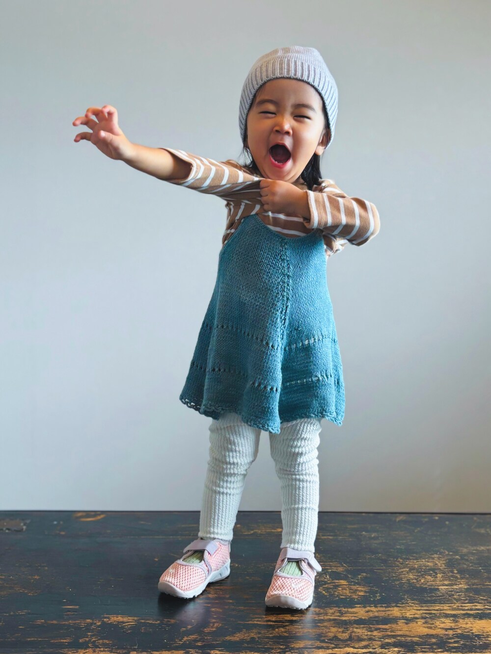 グリーン系のワンピース、ベージュ系のTシャツ/カットソー、ピンク系のスニーカーを着用したキッズの秋コーディネートの2枚目の写真