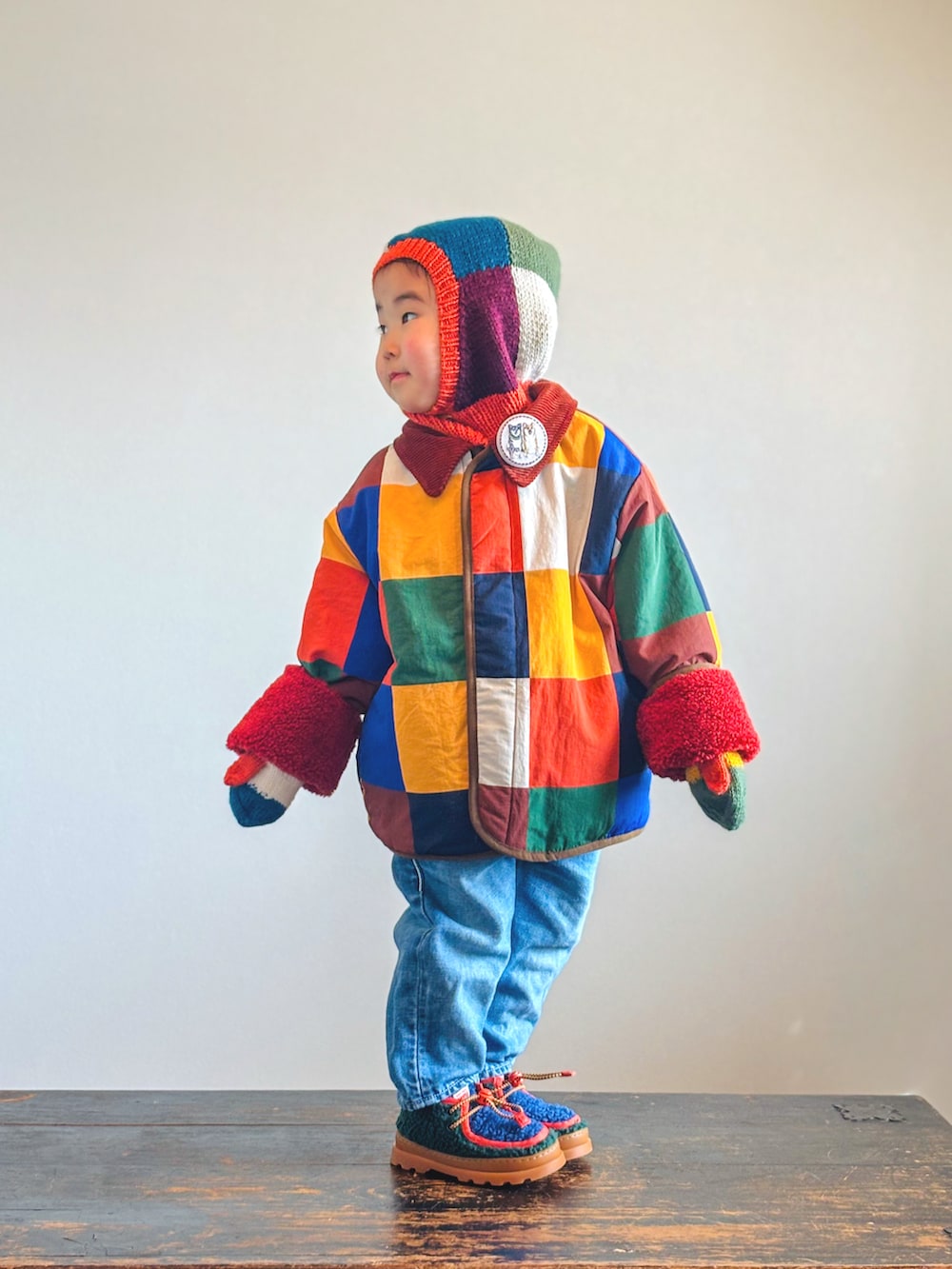 グリーン系のブーツ、ブルー系のデニムパンツ、その他のブルゾンを着用したキッズの冬コーディネートの3枚目の写真