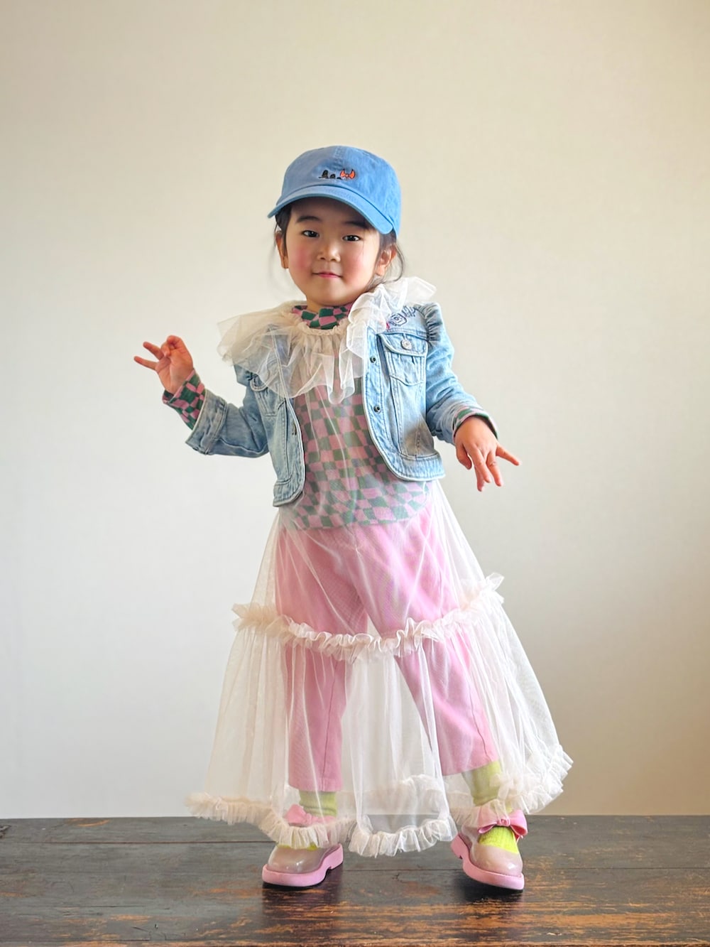 ピンク系のTシャツ/カットソー、ブルー系のデニムジャケット、ホワイト系のワンピースを着用したキッズの春コーディネートの2枚目の写真