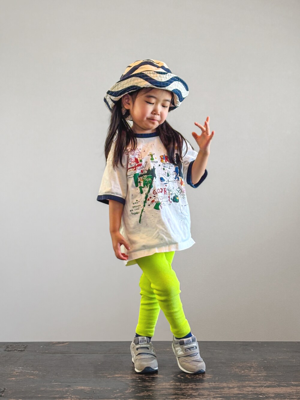 グレー系のスニーカー、ホワイト系のTシャツ/カットソー、イエロー系のレギンス/スパッツを着用したキッズの夏コーディネートの2枚目の写真