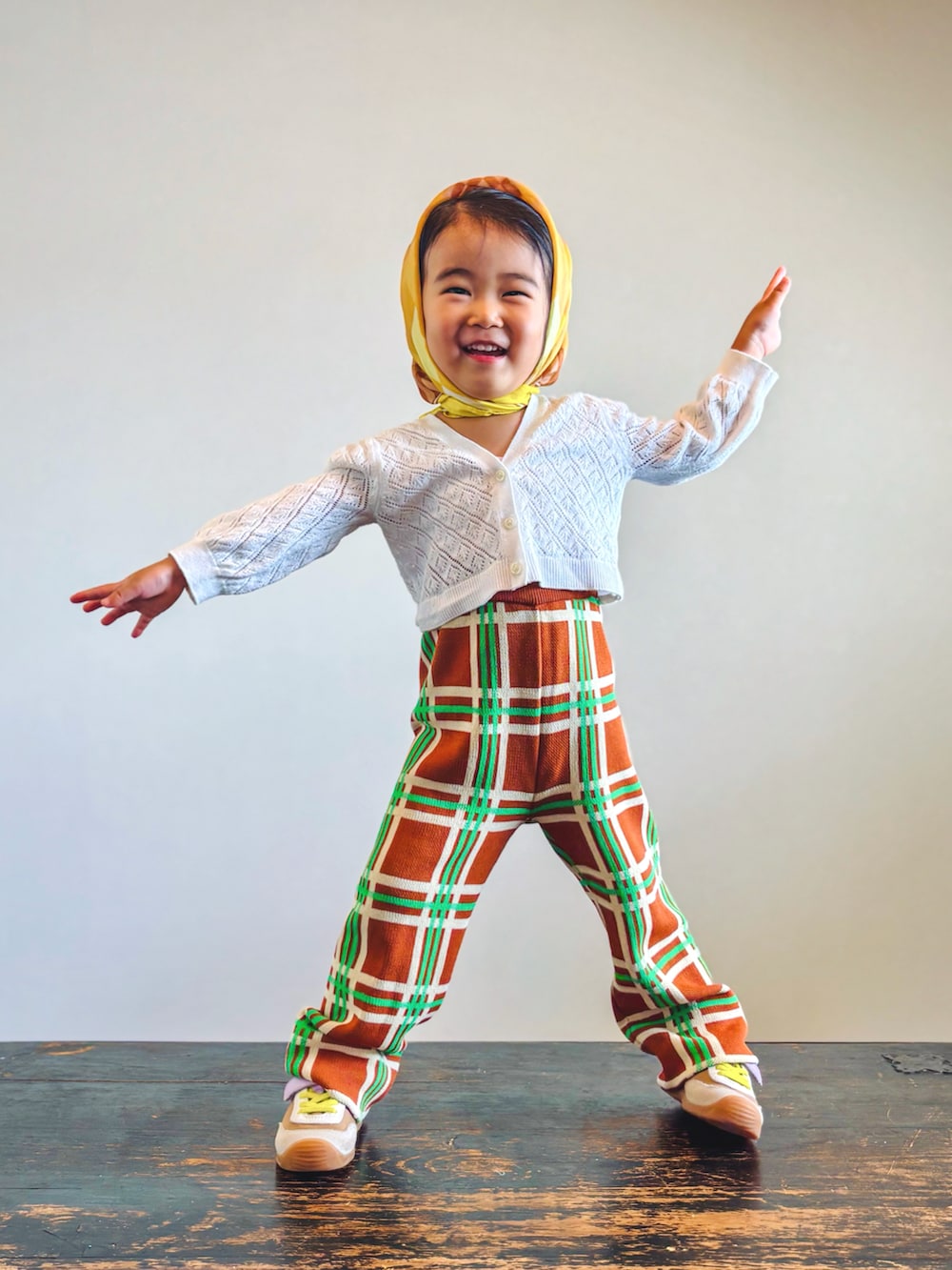 ホワイト系のカーディガン/ボレロ、パープル系のその他パンツ、イエロー系のスニーカーを着用したキッズの秋コーディネートの3枚目の写真