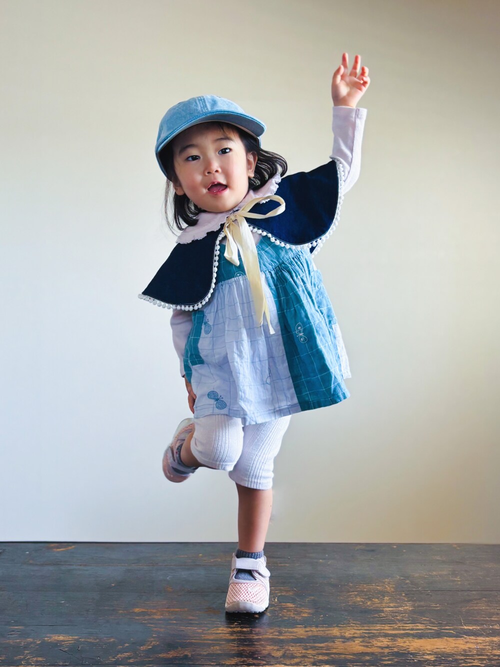 ピンク系のスニーカー、ブルー系のワンピース、ピンク系のTシャツ/カットソーを着用したキッズの春コーディネートの3枚目の写真