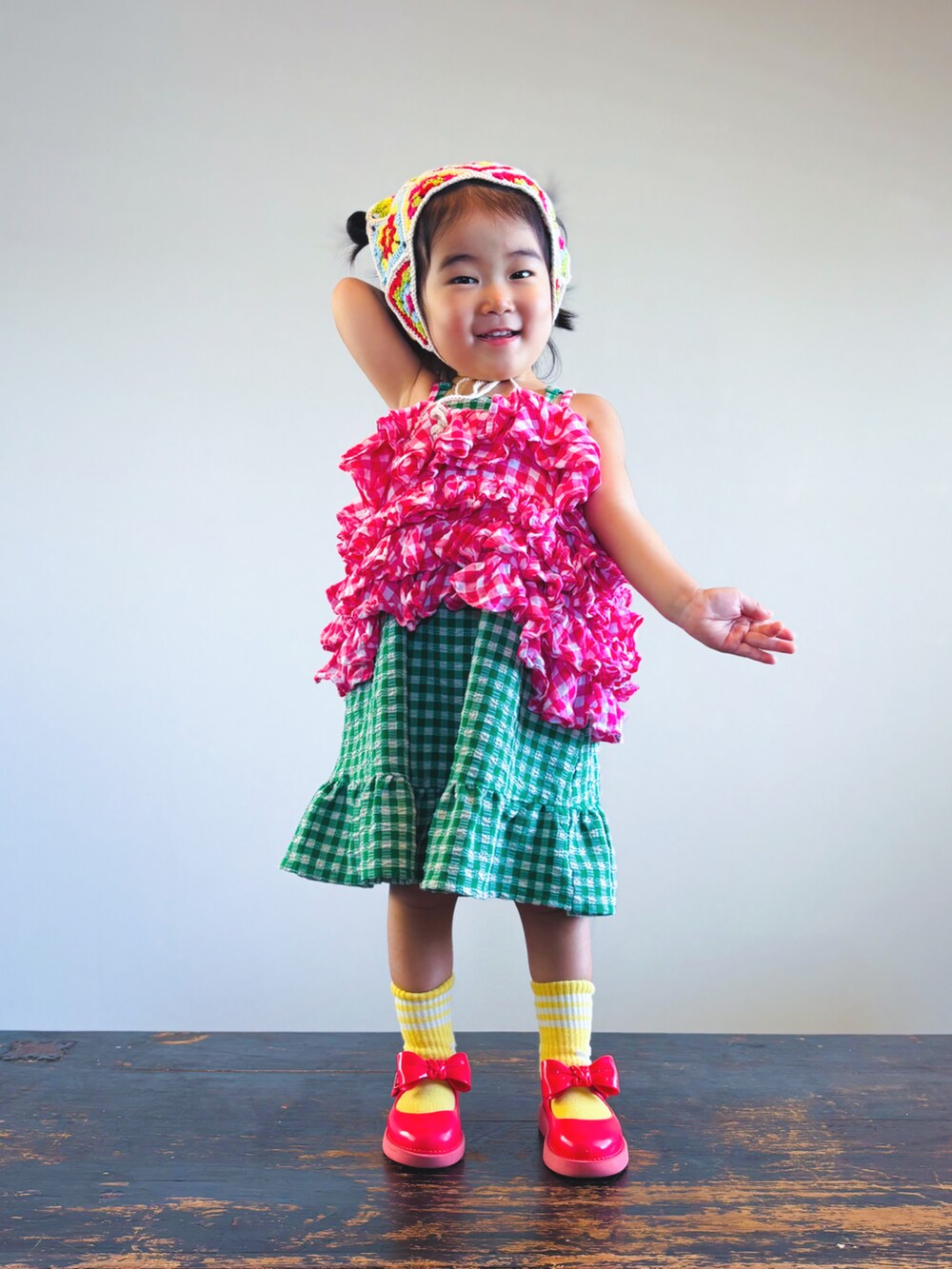 ピンク系のキャミソール、グリーン系のスカート、レッド系のドレスシューズを着用したキッズの夏コーディネートの3枚目の写真