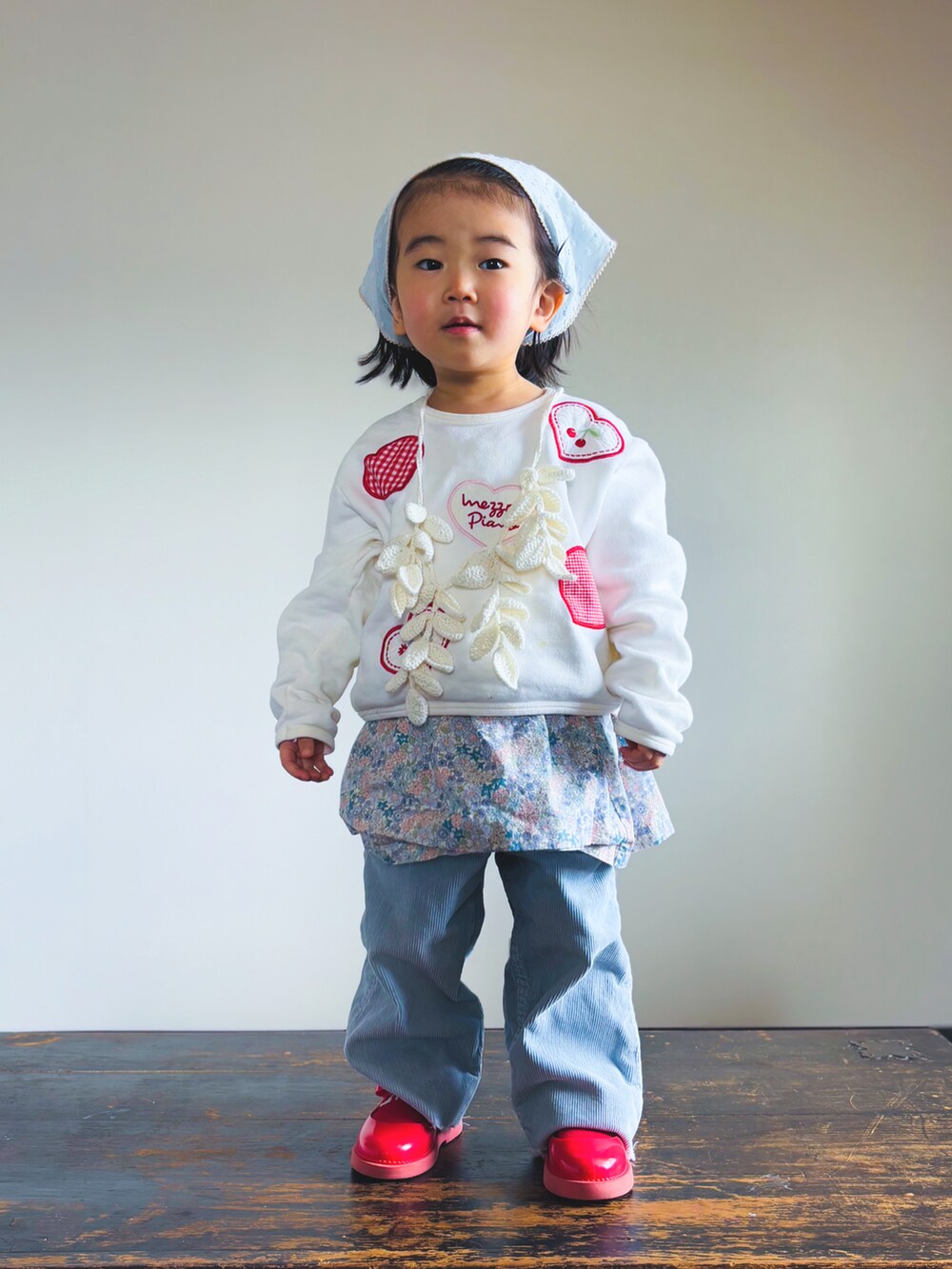 ホワイト系のスウェット、ブルー系のパンツ、レッド系のドレスシューズを着用したキッズの春コーディネートの2枚目の写真