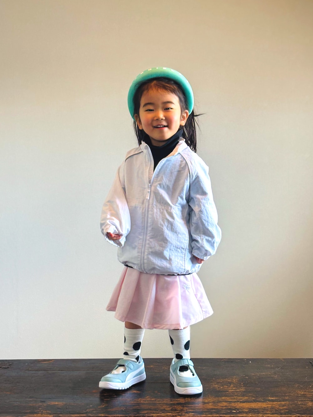 ピンク系のスカート、グリーン系のスニーカー、ブラック系のTシャツ/カットソーを着用したキッズの春コーディネートの2枚目の写真