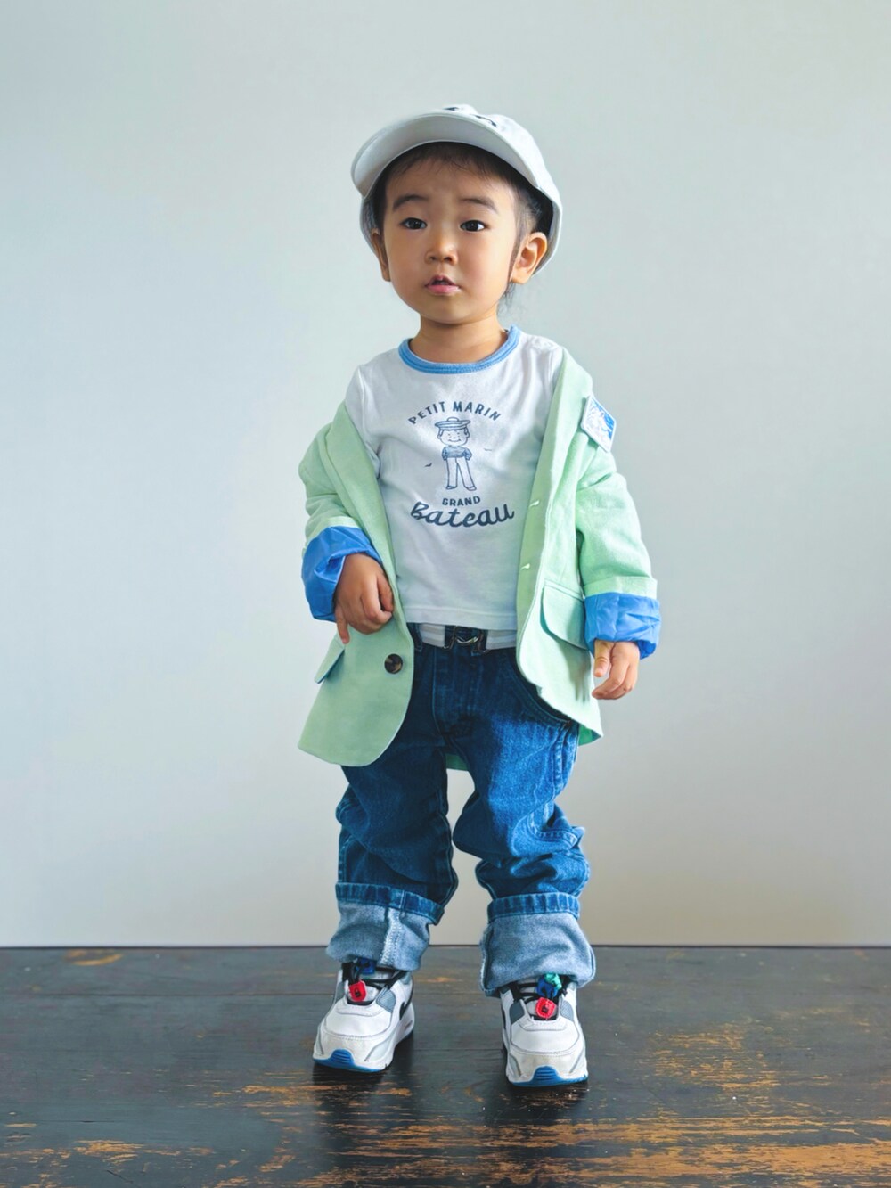 グリーン系のテーラードジャケット、ホワイト系のTシャツ/カットソー、ブルー系のデニムパンツを着用したキッズの秋コーディネートの2枚目の写真