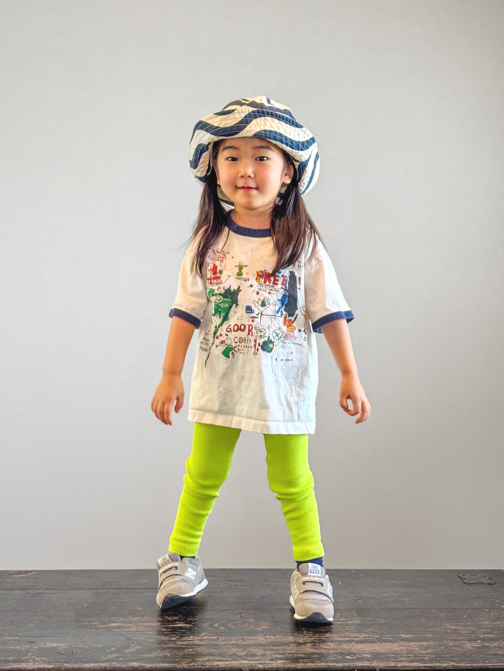グレー系のスニーカー、ホワイト系のTシャツ/カットソー、イエロー系のレギンス/スパッツを着用したキッズの夏コーディネートの3枚目の写真