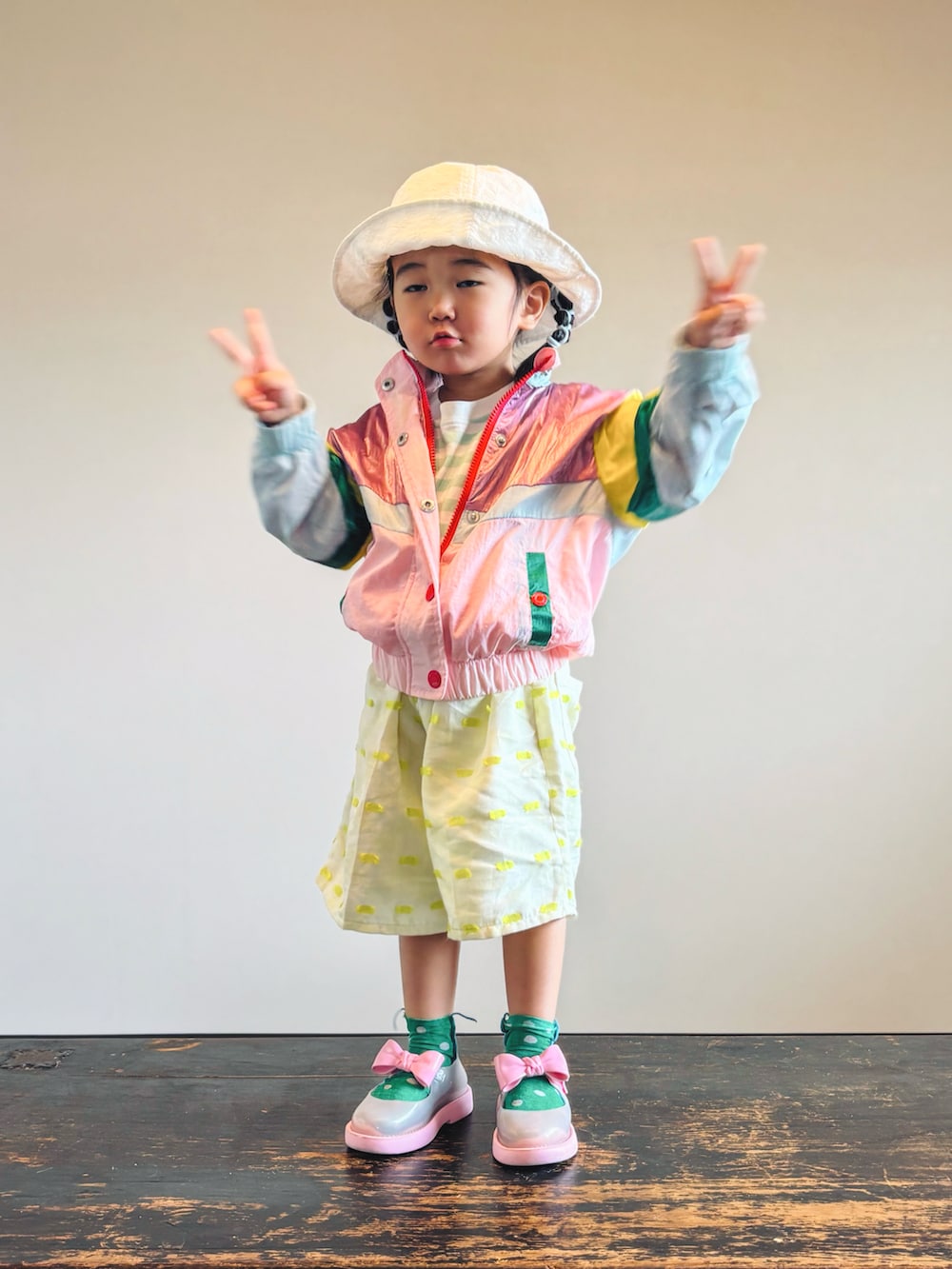 グリーン系のTシャツ/カットソー、ピンク系のセットアップ、イエロー系のパンツを着用したキッズの秋コーディネートの4枚目の写真