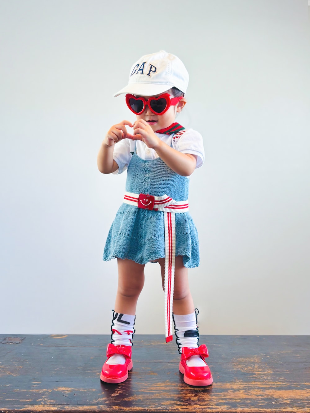 ホワイト系のポロシャツ、グリーン系のワンピース、レッド系のドレスシューズを着用したキッズの夏コーディネートの2枚目の写真