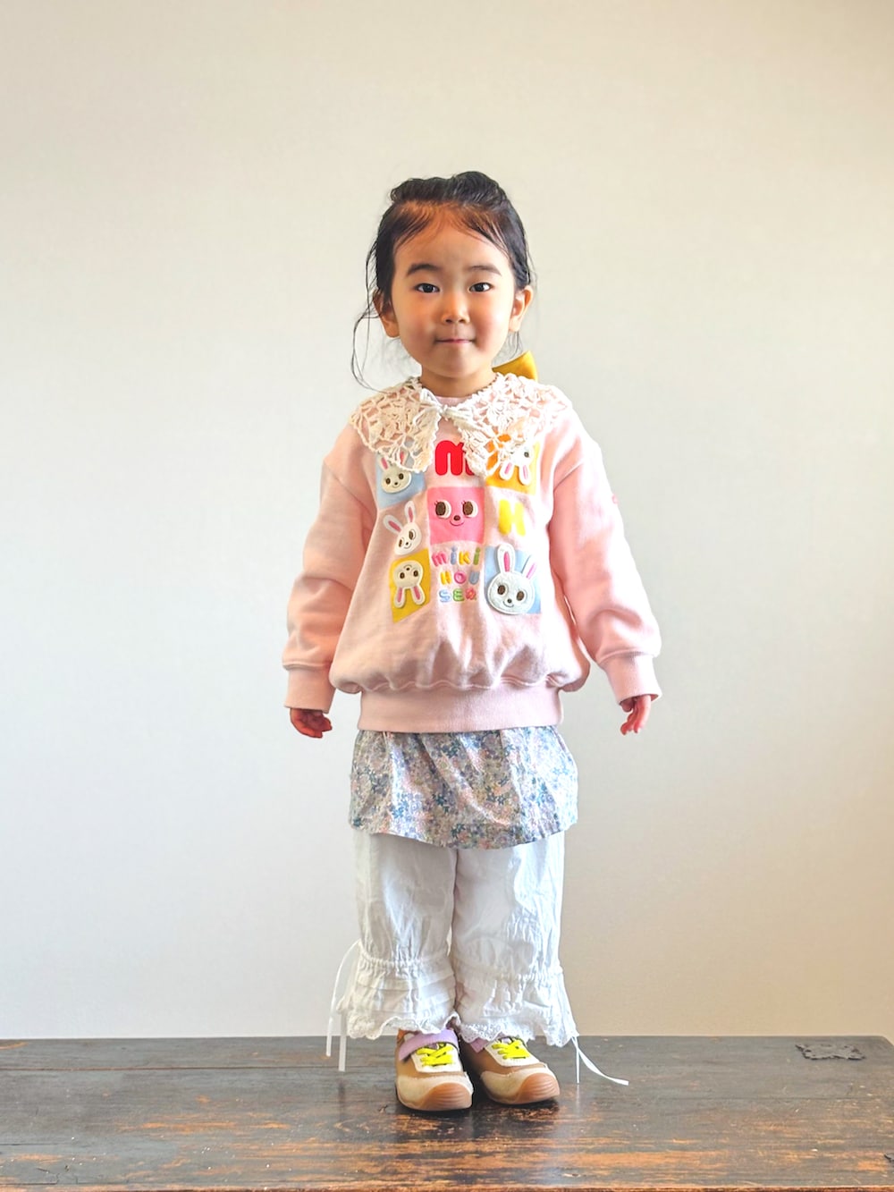 ピンク系のスウェット、ホワイト系のその他パンツ、イエロー系のスニーカーを着用したキッズの春コーディネートの2枚目の写真