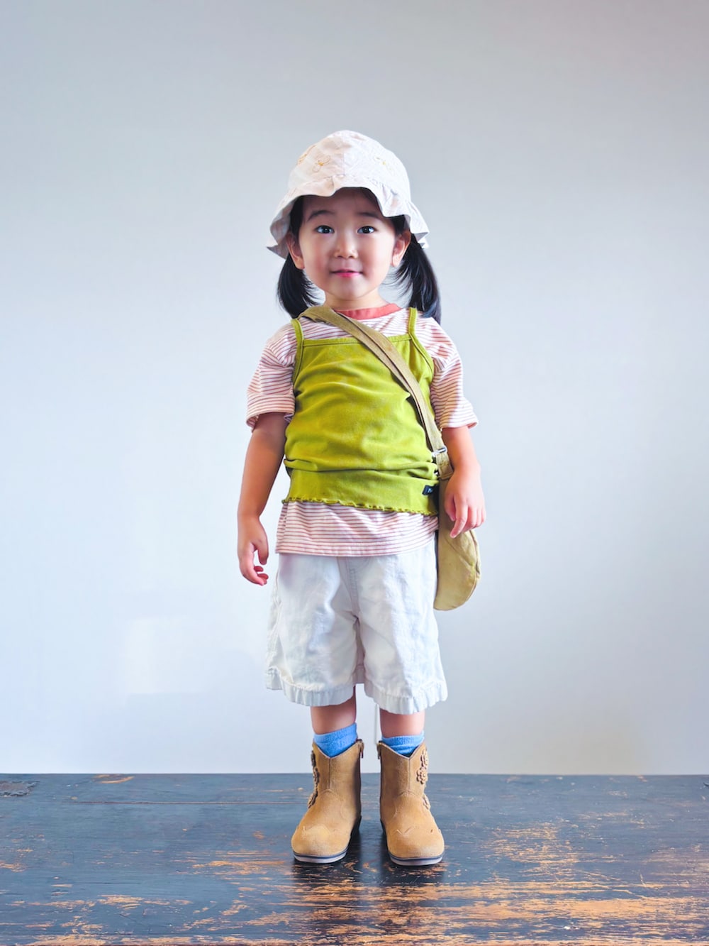 オレンジ系のTシャツ/カットソー、グリーン系のキャミソール、ホワイト系のその他パンツを着用したキッズの秋コーディネートの3枚目の写真