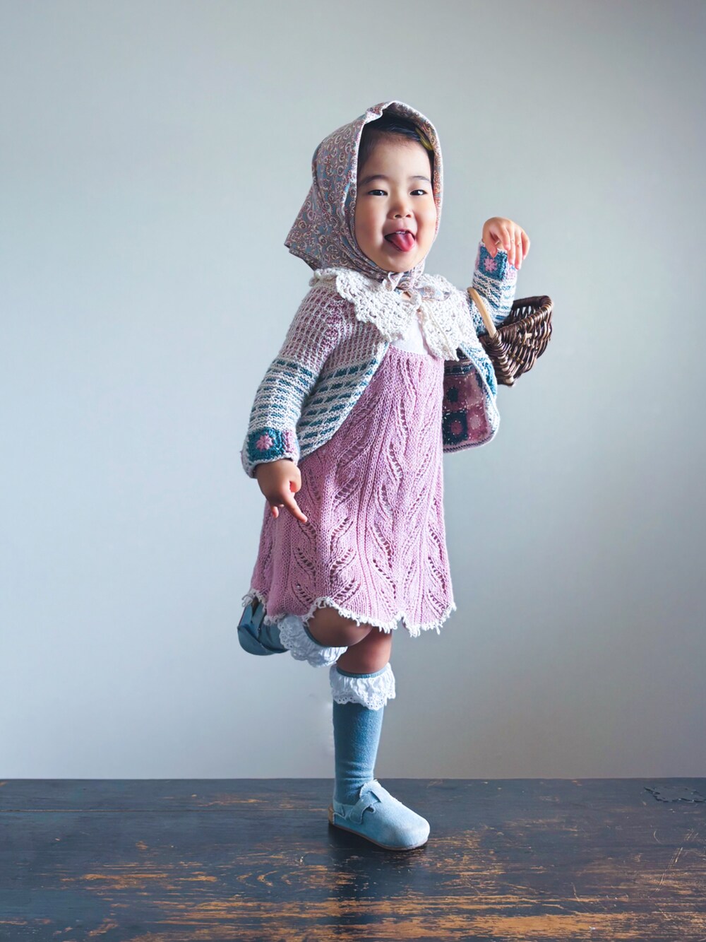 ブルー系のサンダル、ピンク系のワンピース、ブラウン系のかごバッグを着用したキッズの春コーディネートの2枚目の写真