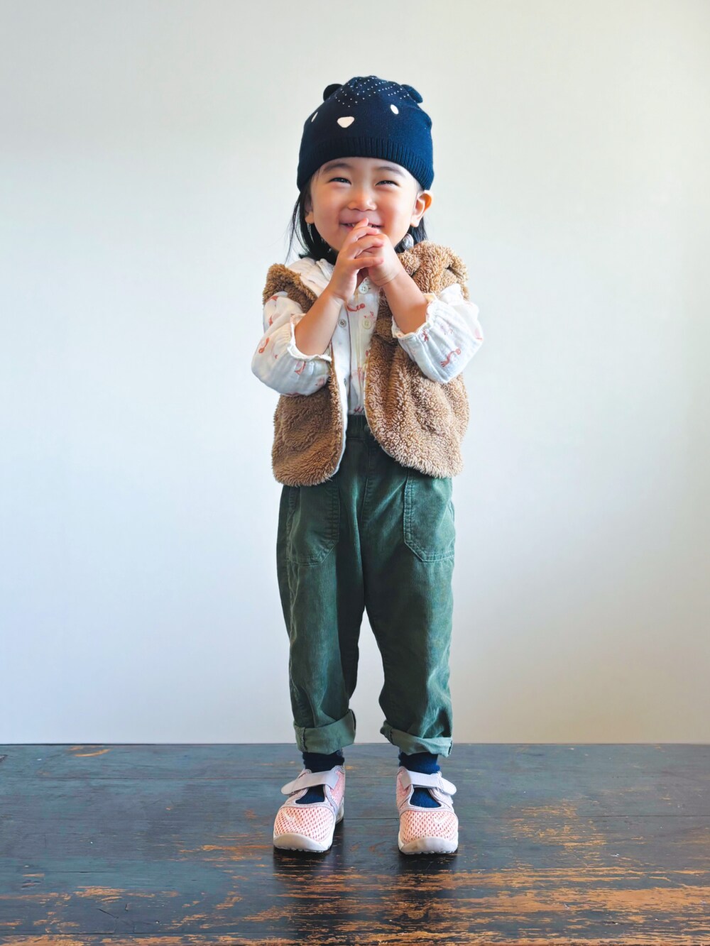 グリーン系のパンツ、ピンク系のスニーカー、ベージュ系のシャツ/ブラウスを着用したキッズの秋コーディネートの2枚目の写真