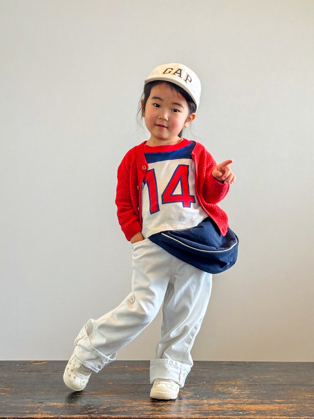 ベージュ系のスニーカー、レッド系のTシャツ/カットソー、レッド系のカーディガン/ボレロを着用したキッズの春コーディネートの3枚目の写真