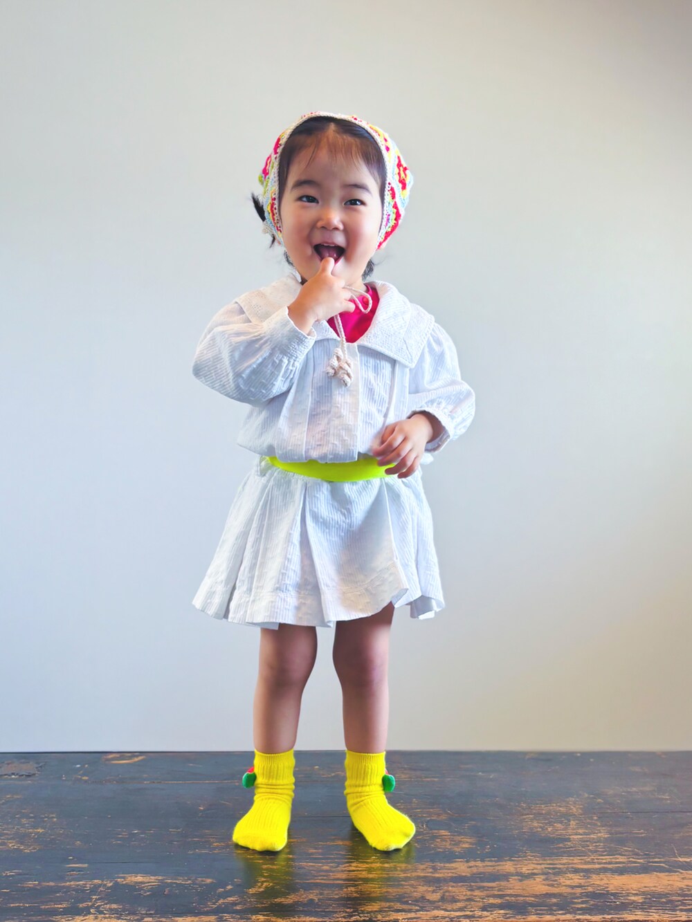 ホワイト系のワンピース、ブラウン系のかごバッグ、ホワイト系のTシャツ/カットソーを着用したキッズの春コーディネートの3枚目の写真